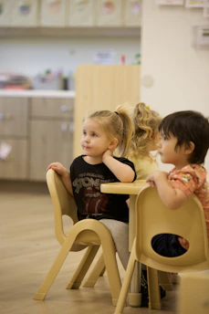 Young children sitting at a table in a classroom.