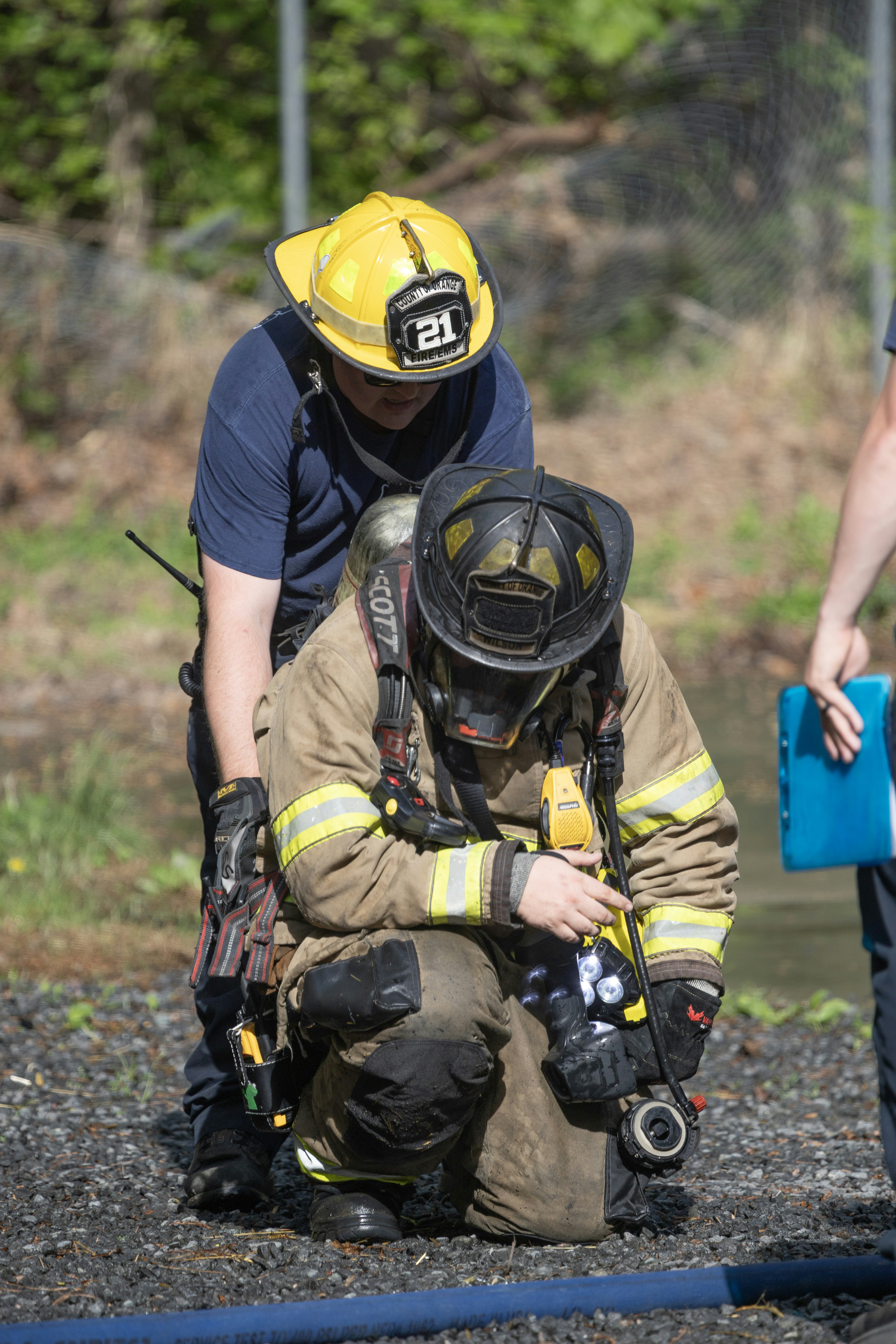 Feuerwehrleute in Schutzkleidung üben eine Übung im Freien.