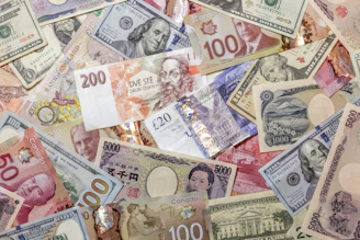 A chaotic pile of various international banknotes