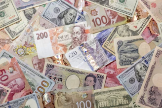 A chaotic pile of various international banknotes