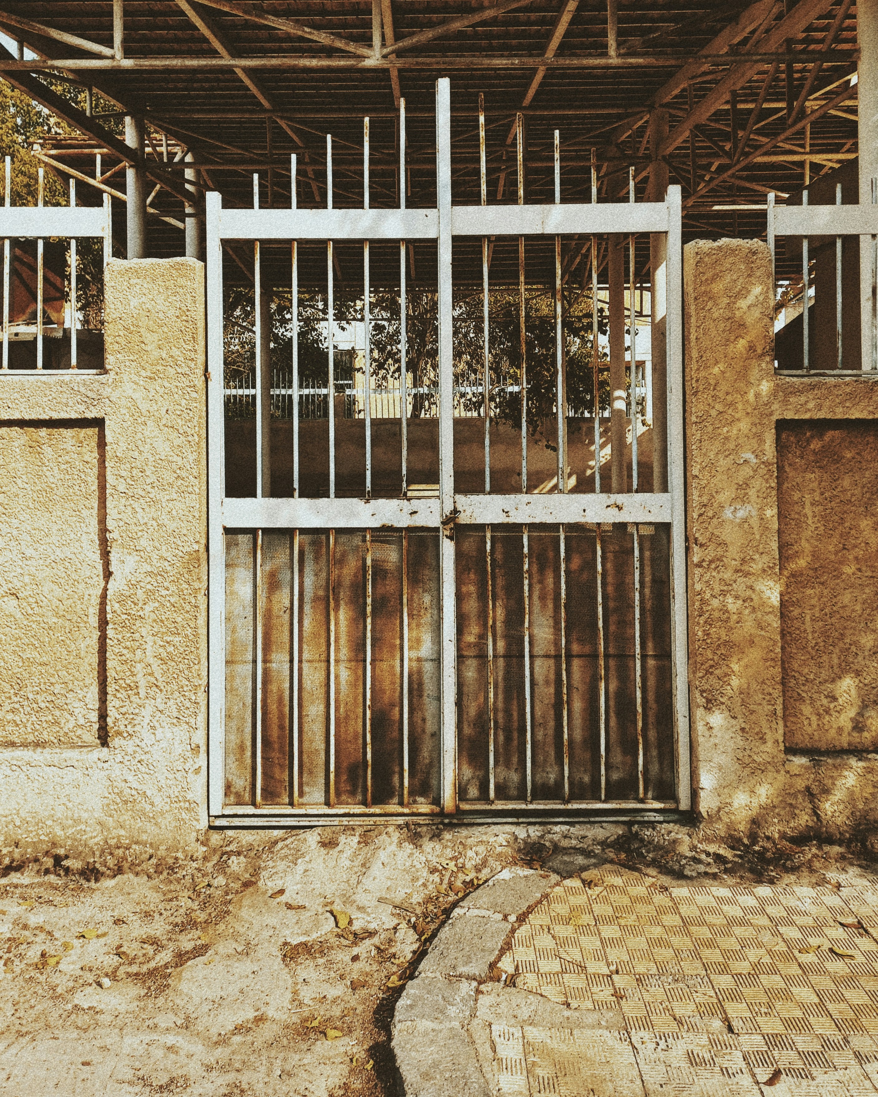 A rusty metal gate with a concrete wall. photo – Free Texture Image on ...