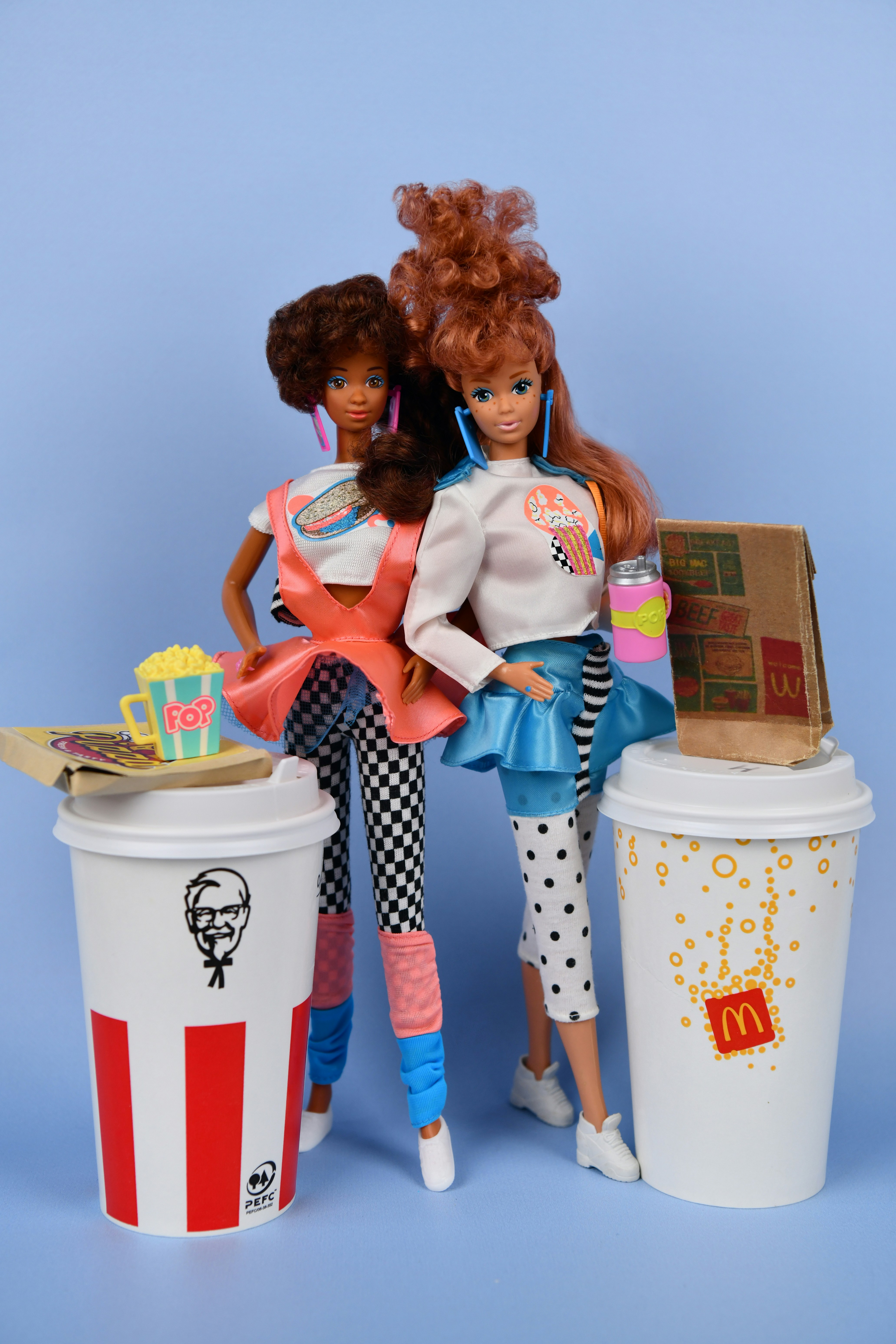 Two dolls with fast food and drinks