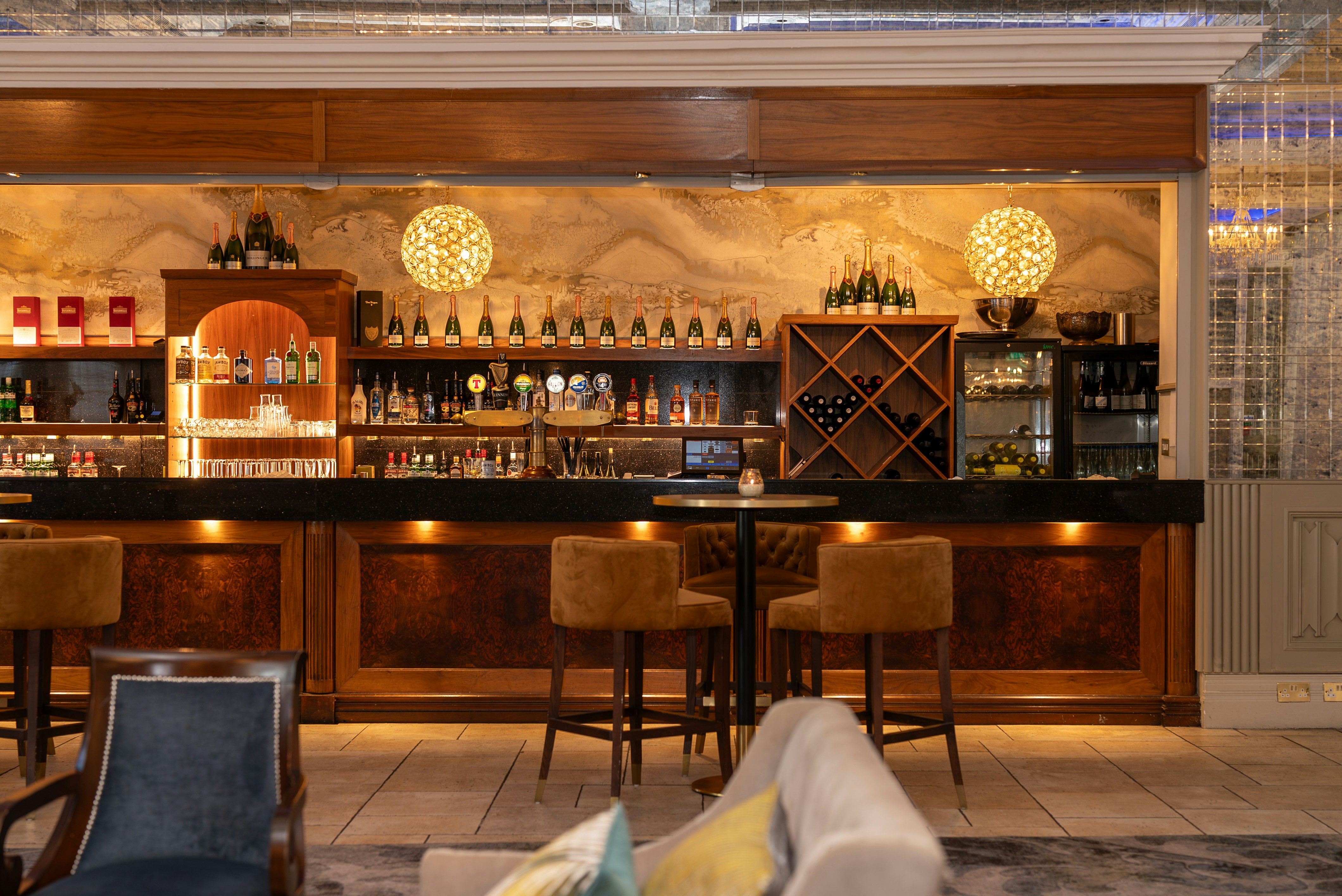 A well-stocked bar with stools and seating.