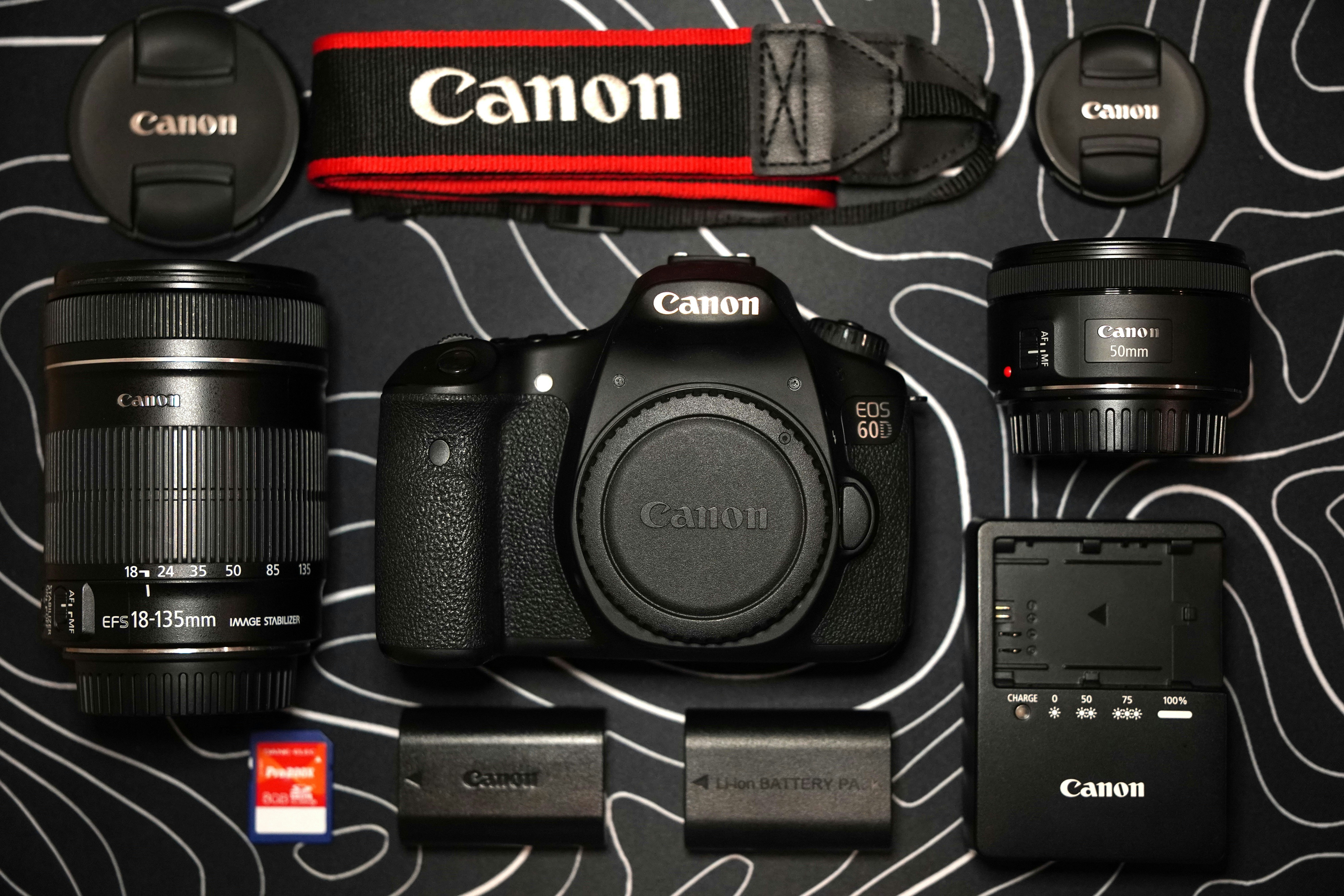Appareil photo Canon avec objectifs et accessoires disposés.