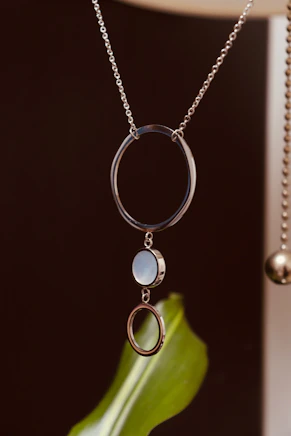 A silver necklace with three circular pendants