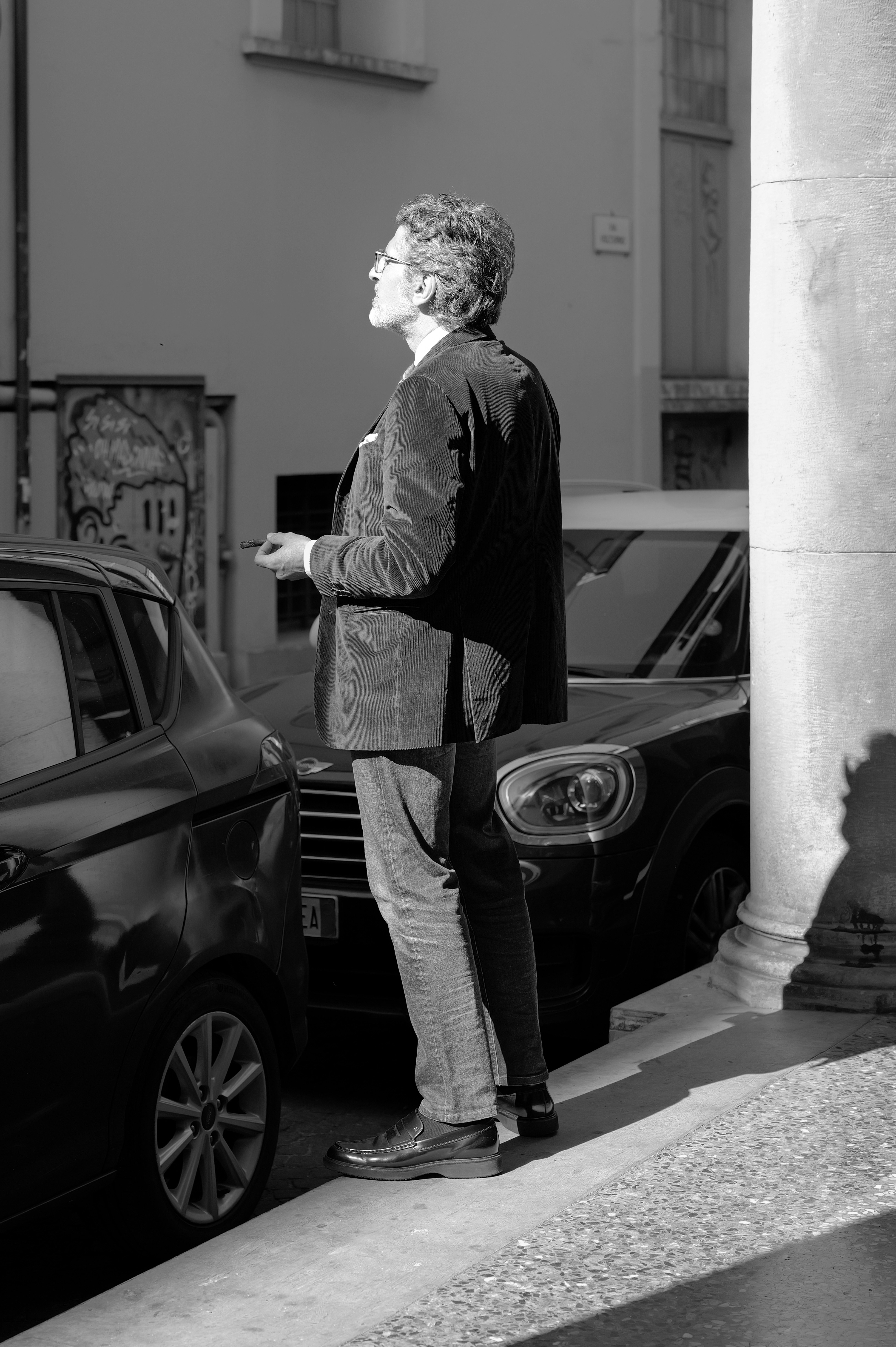 Man in suit looking up on city street