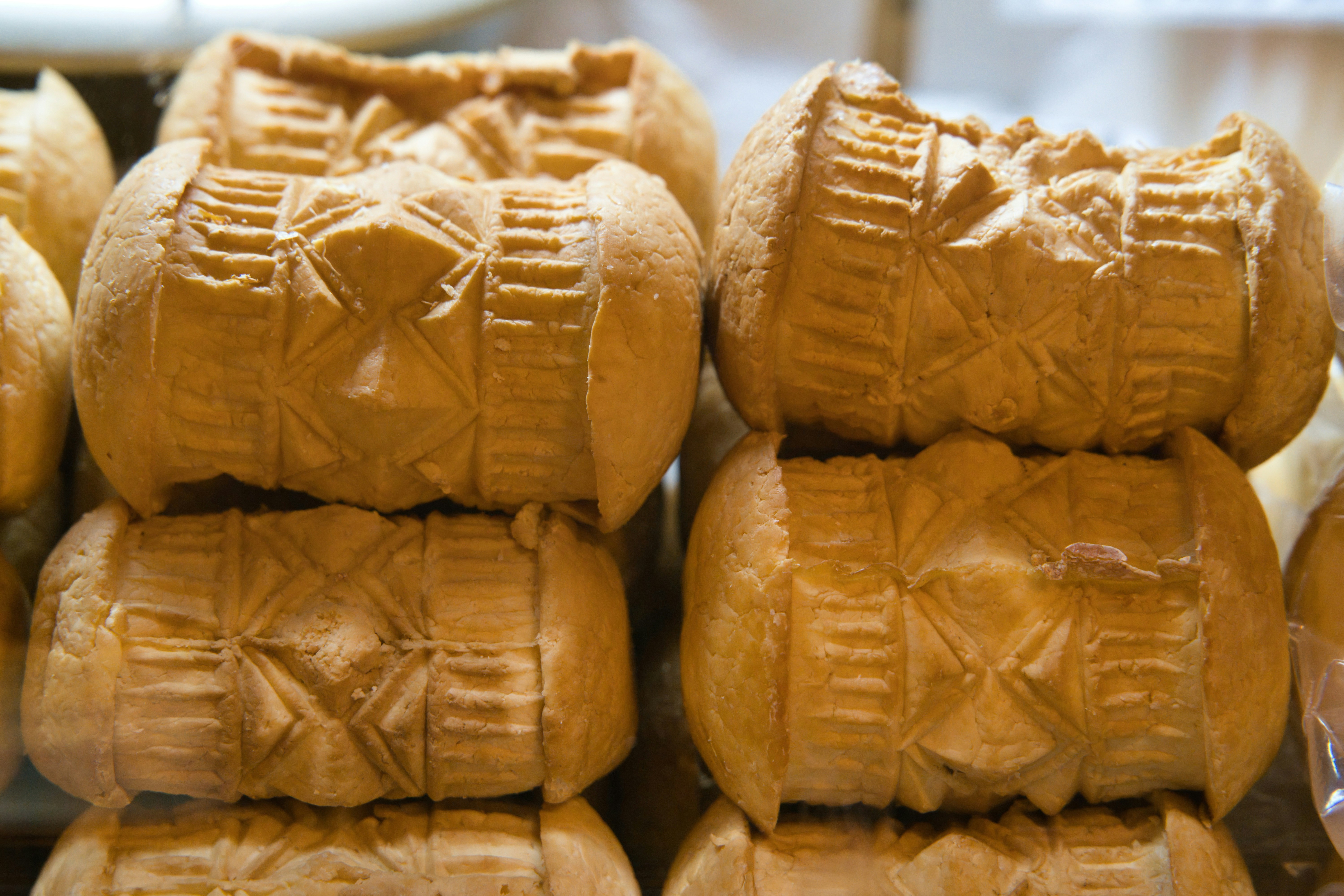 Stacked wooden cheese molds with carved patterns
