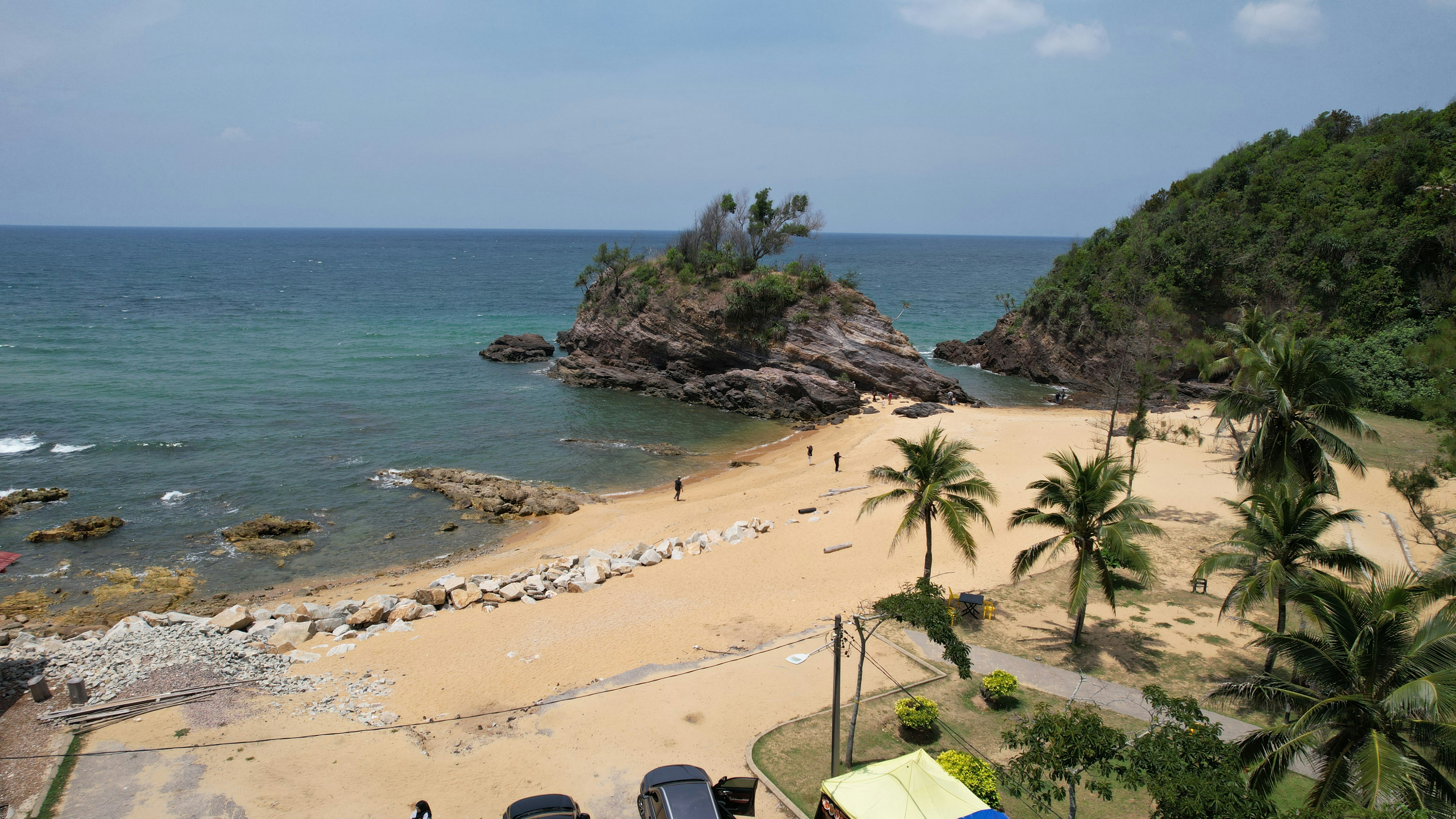 岩だらけの島とヤシの木がある熱帯のビーチ