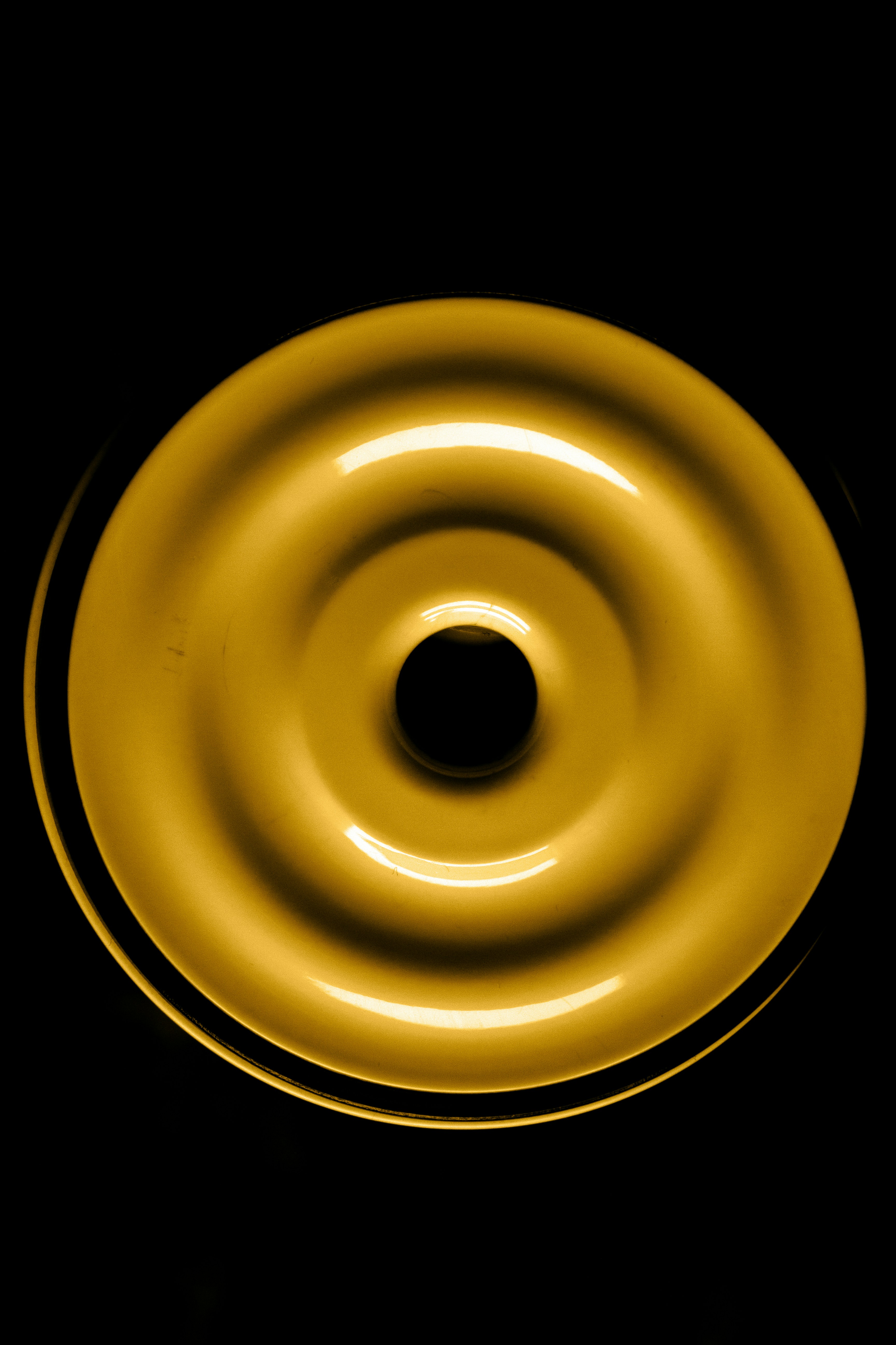 Un oggetto circolare dorato con increspature su sfondo nero