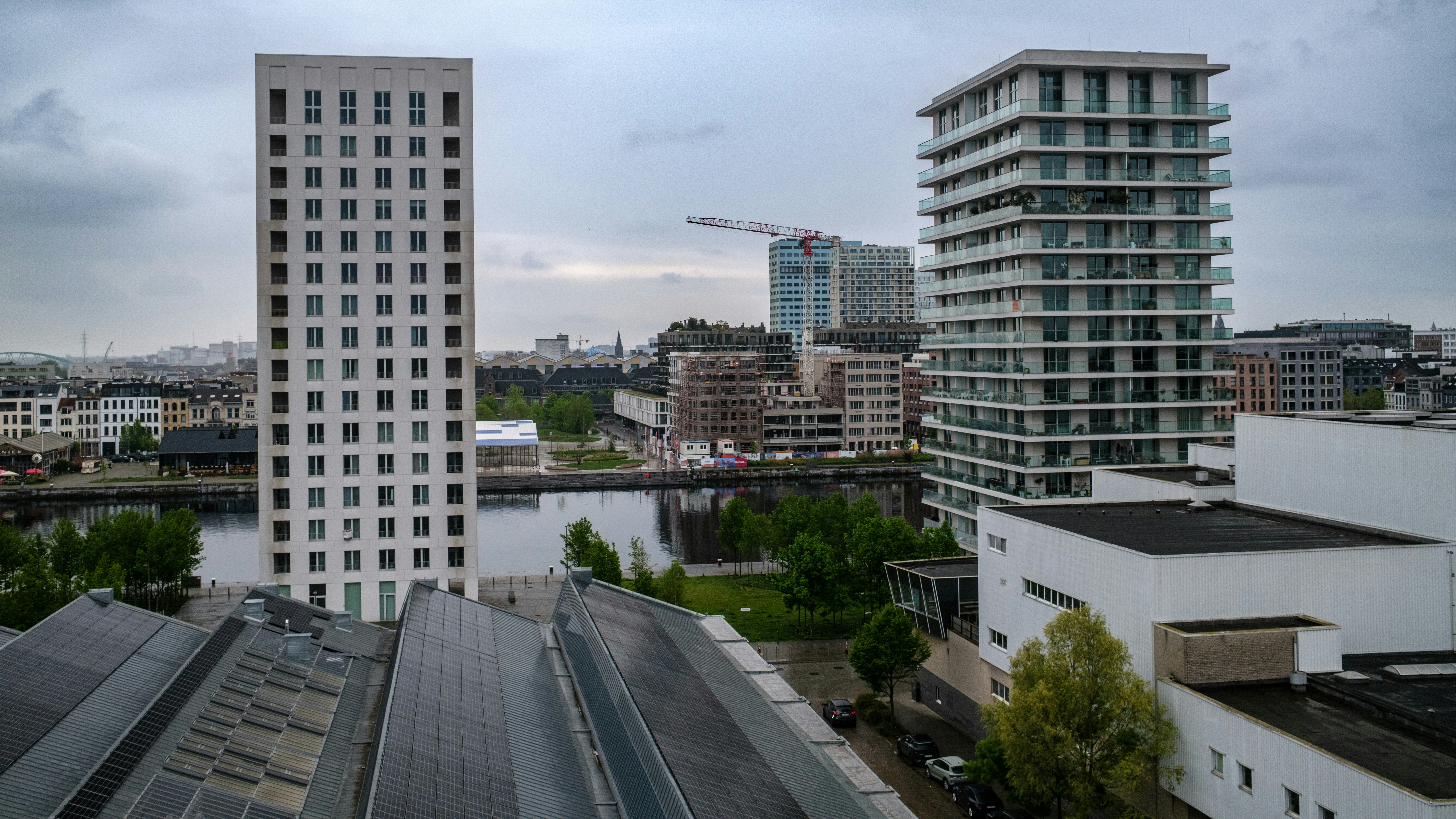 Edificios modernos dan vistas a un río tranquilo bajo cielos nublados.