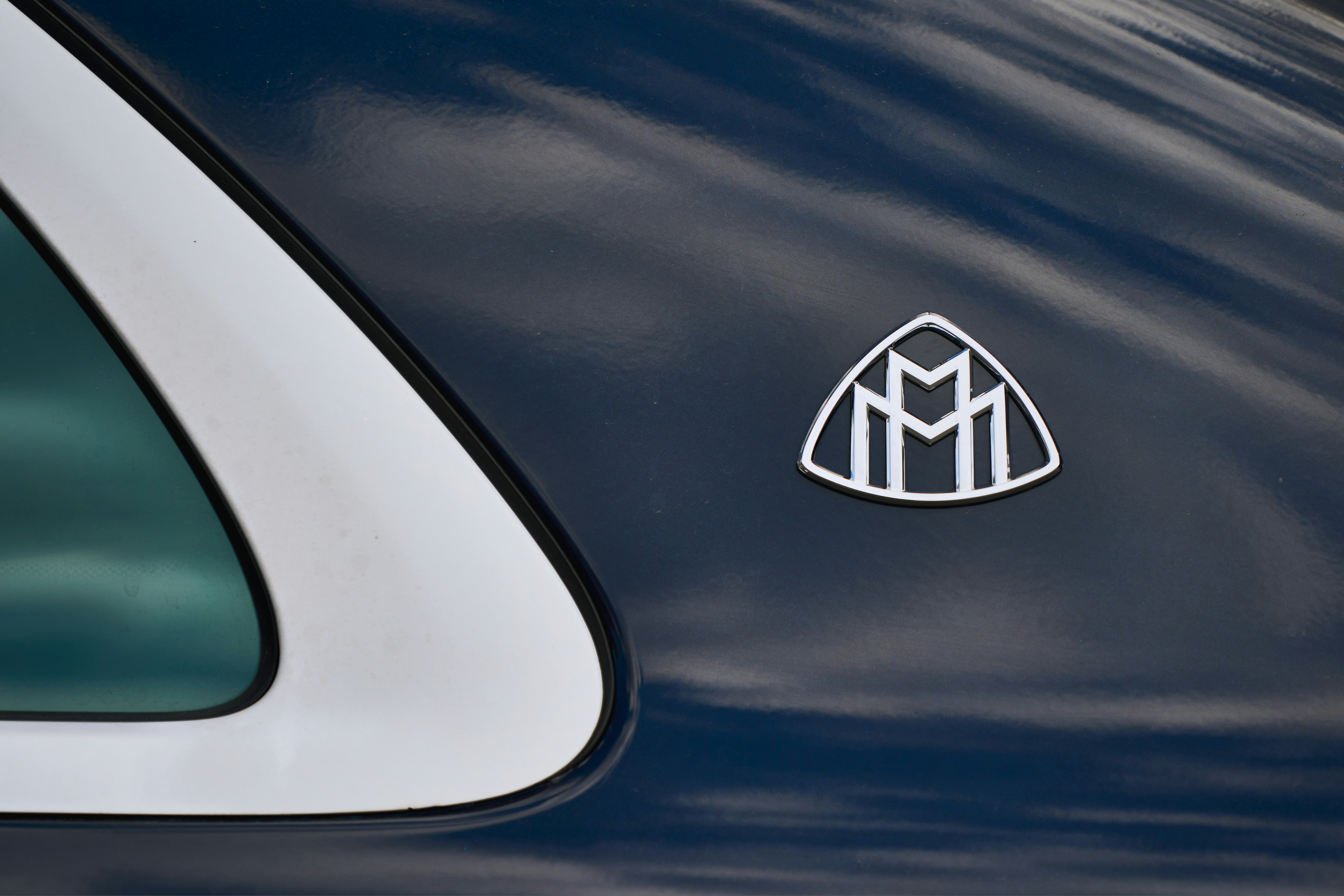 Close-up of a maybach emblem on a dark car