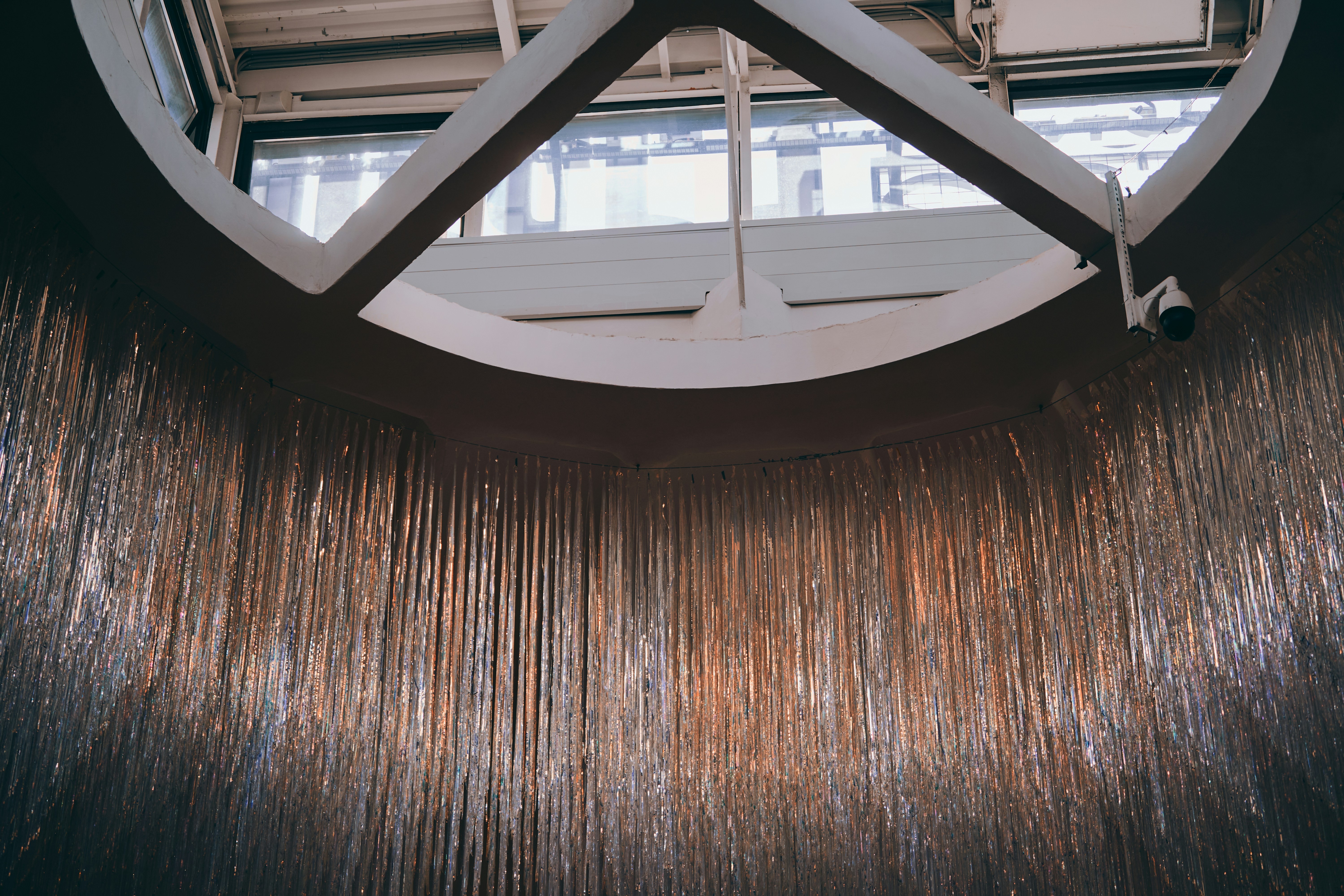 Shiny metallic strands hanging from a circular structure.