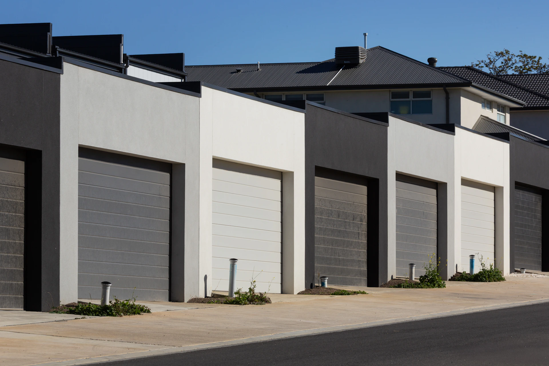 Row of modern garages with dark gray and white doors