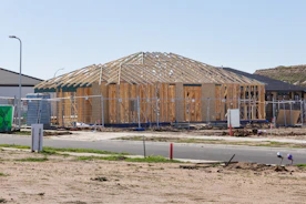 New house frame under construction with fencing