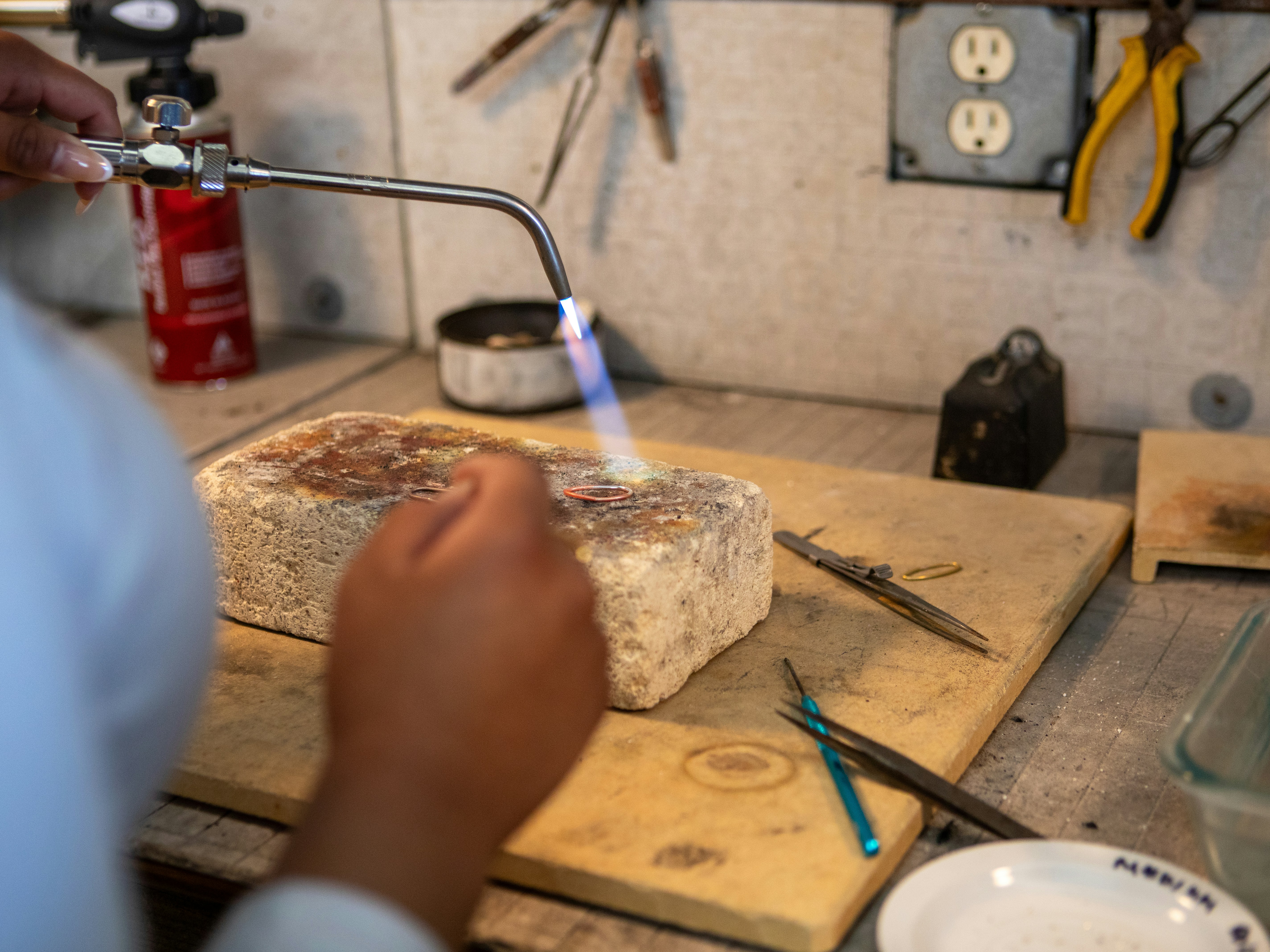 Artisan uses torch on rough material for jewelry making.