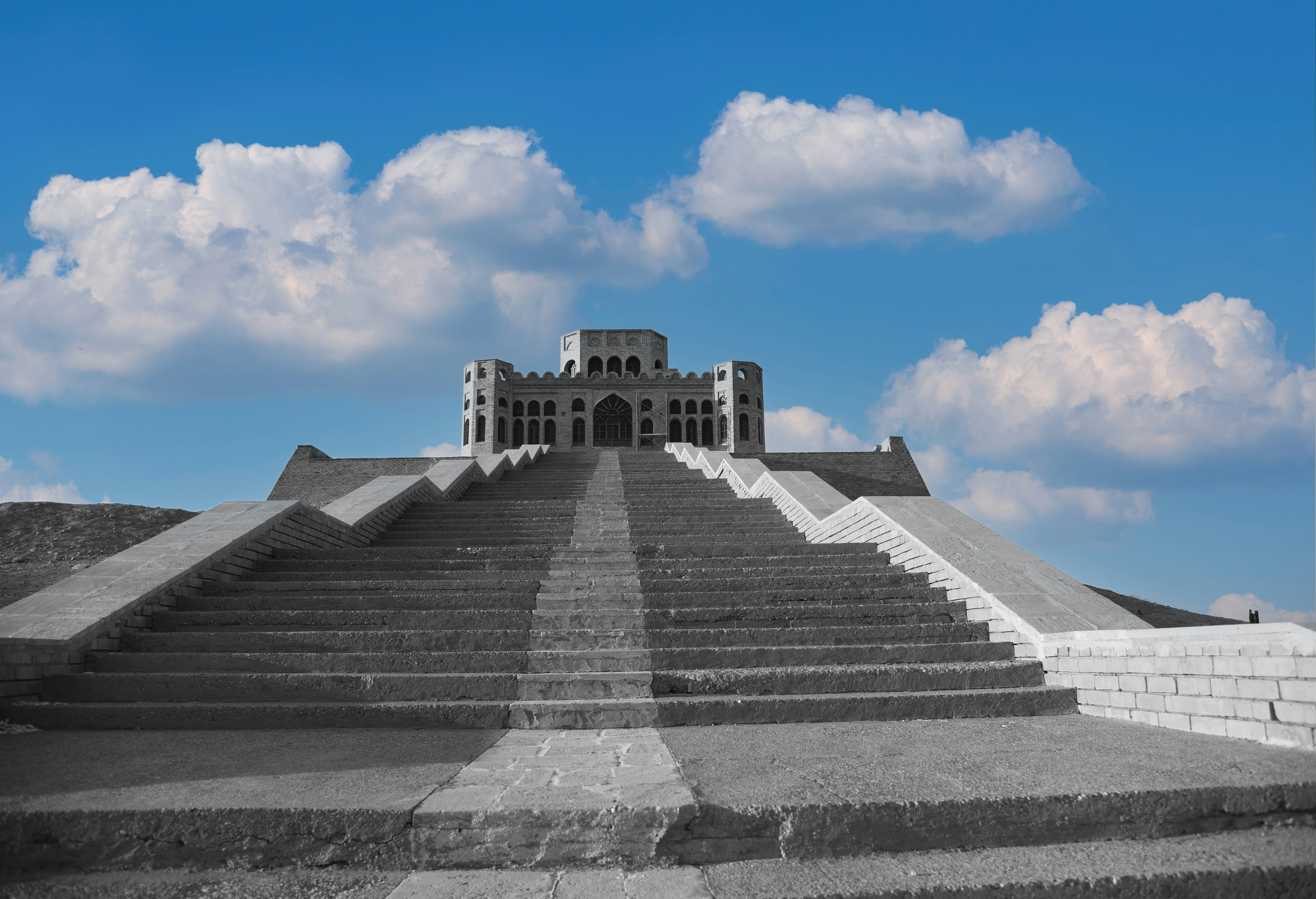 Grand staircase leading to a castle under blue sky