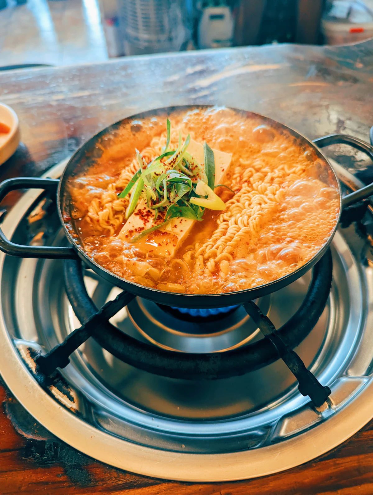 Nồi haejangguk sôi sùng sục với đậu phụ và miến trên bếp