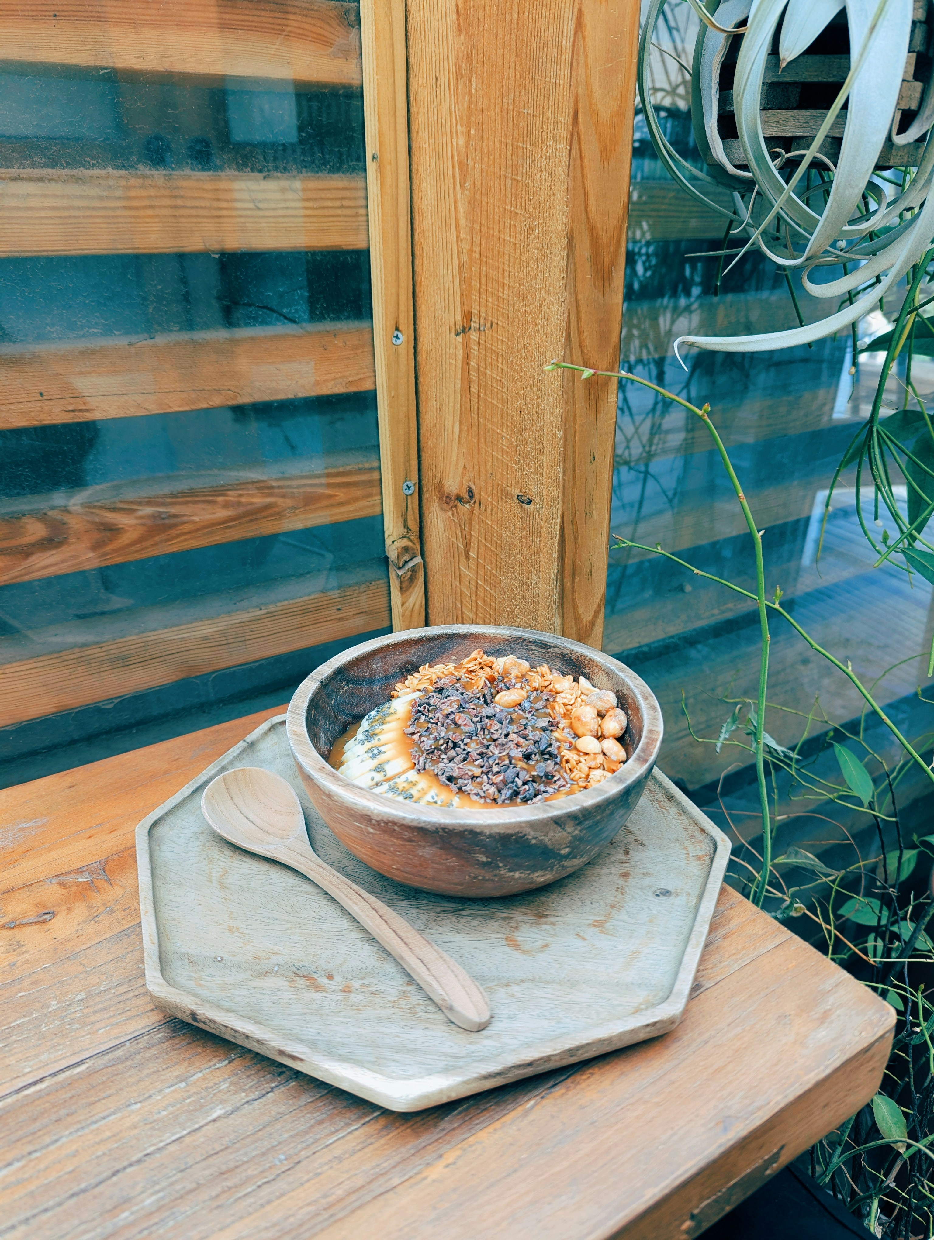 Mangkuk kayu berisi granola dan buah.