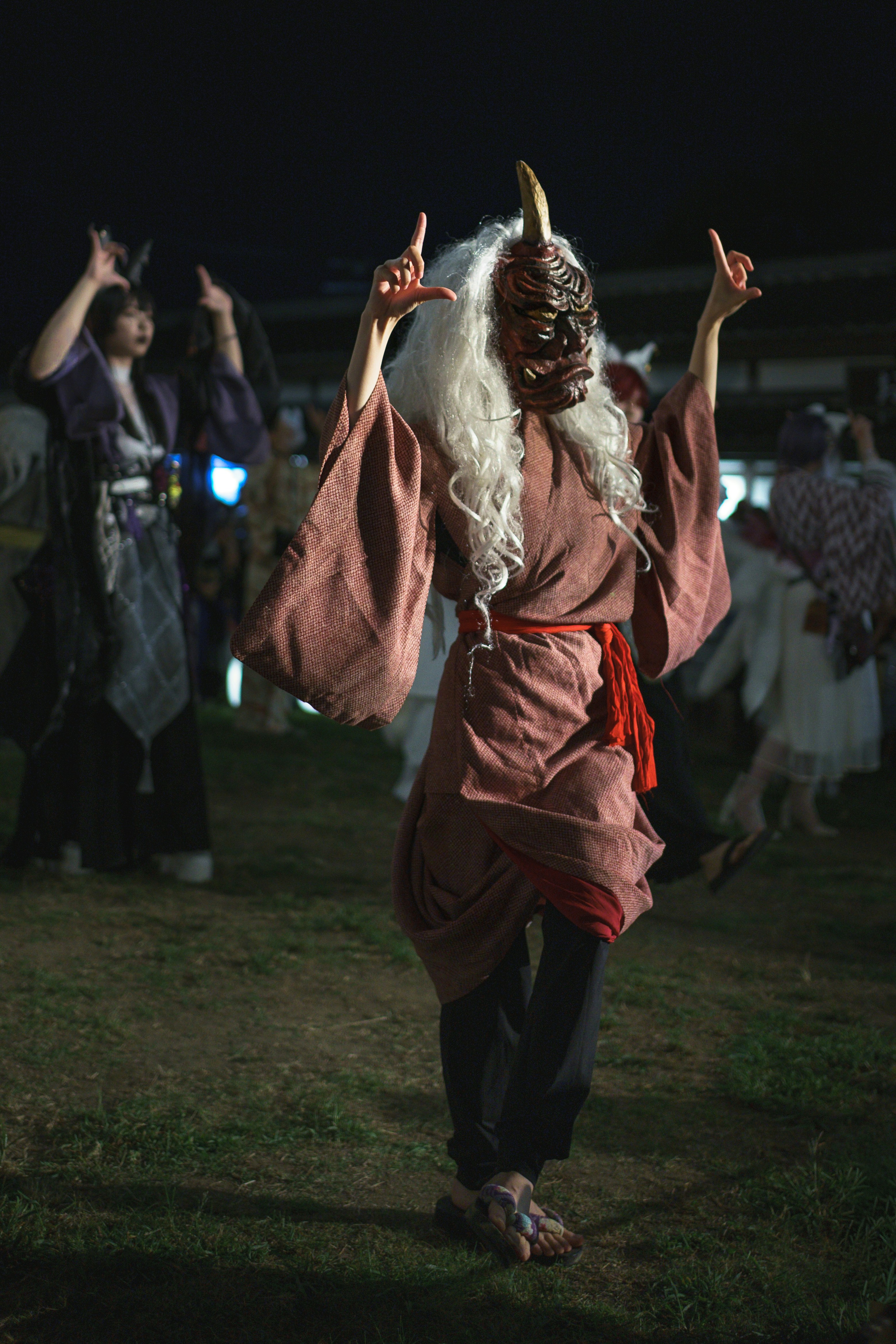Person in a mask and costume dancing at night
