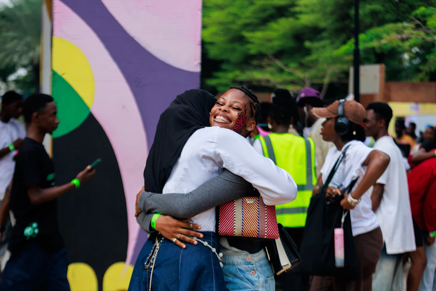 Two volunteers hugging and laughing at a community event