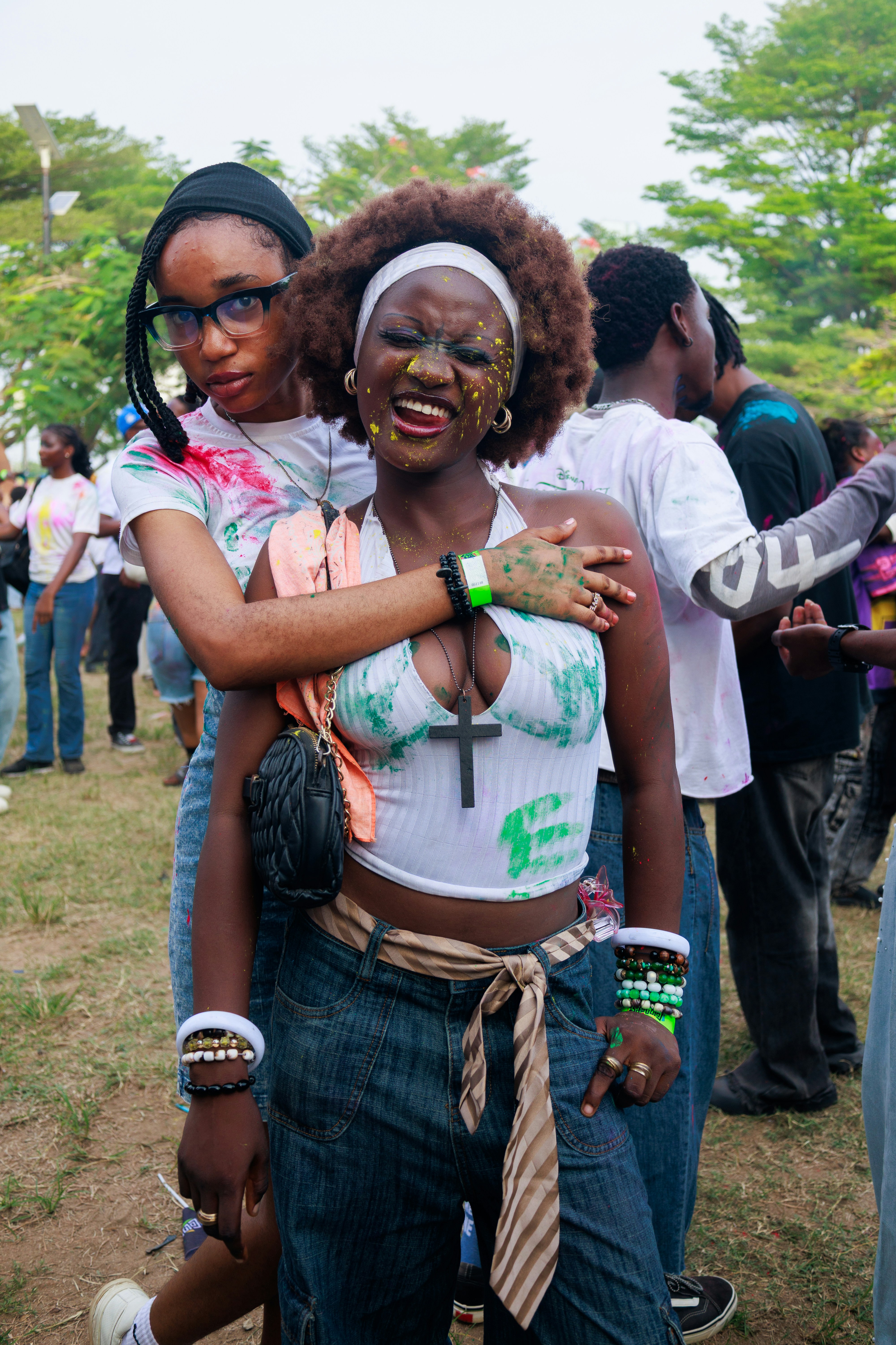 Two young women with colorful paint on faces and bodies.