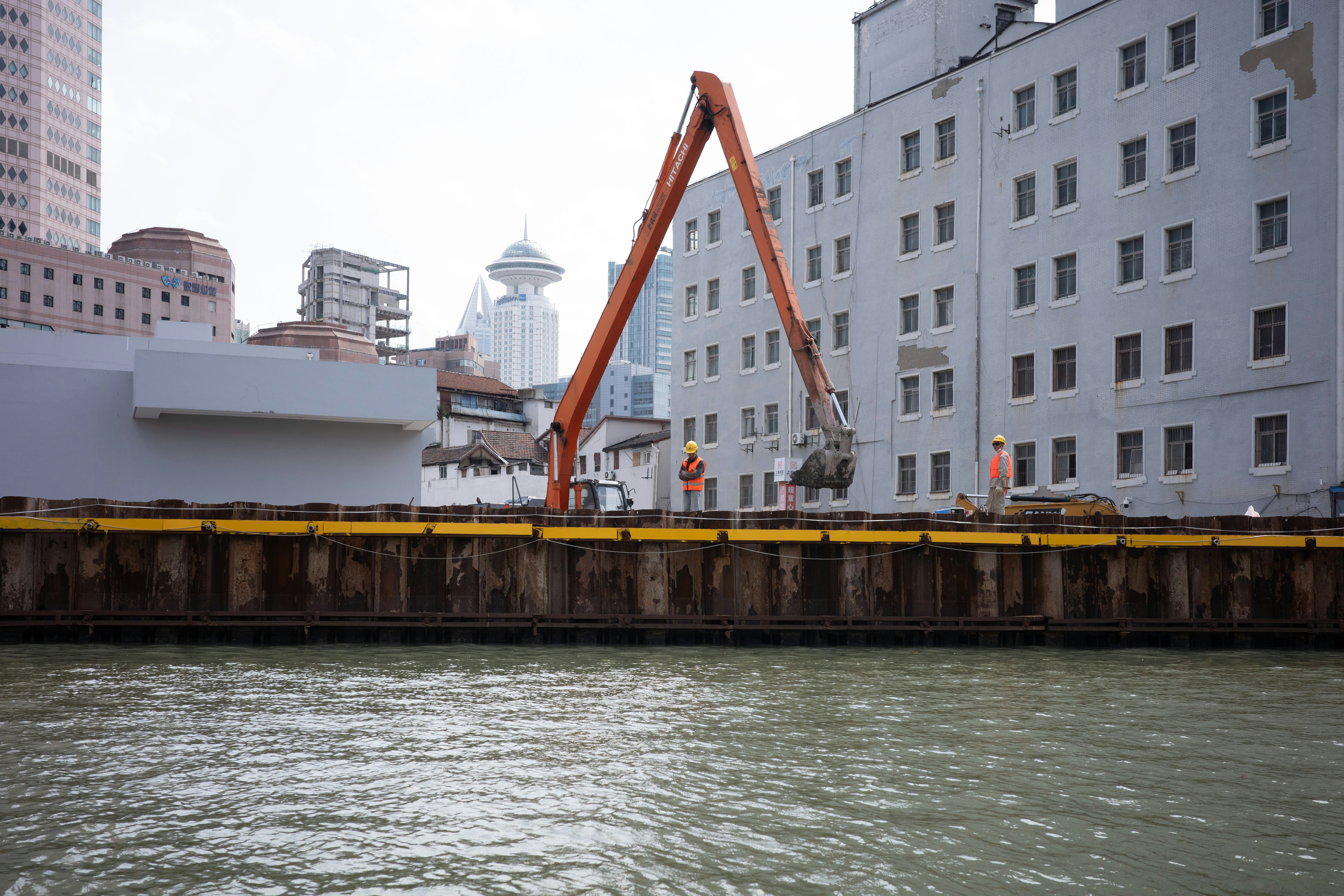 Construction crane demolishing building near waterfront