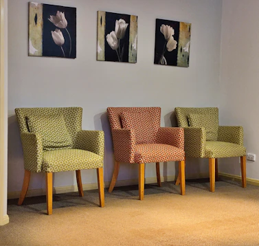 Three chairs in a waiting room with floral art