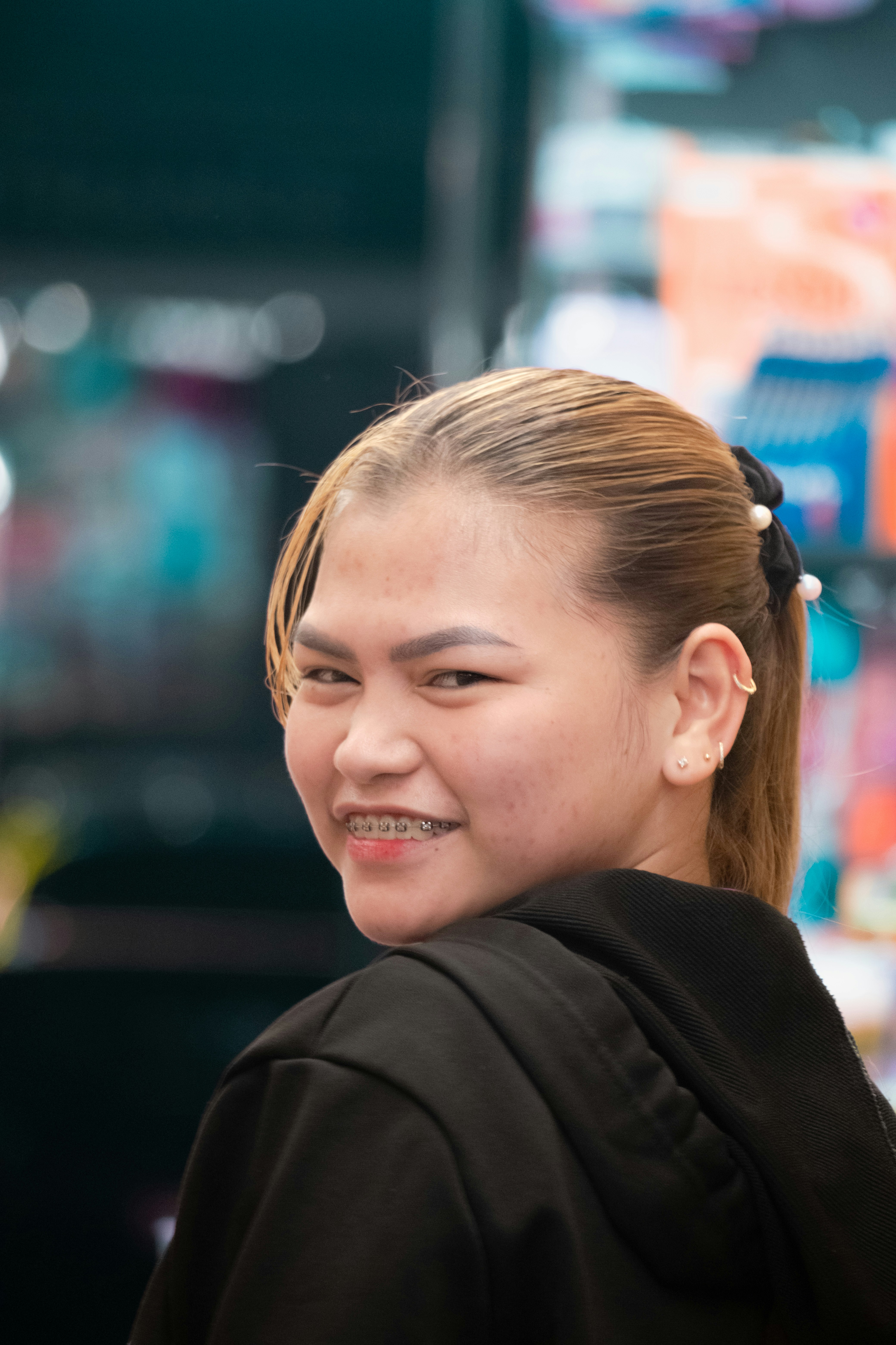 A woman with blonde hair smiles over her shoulder