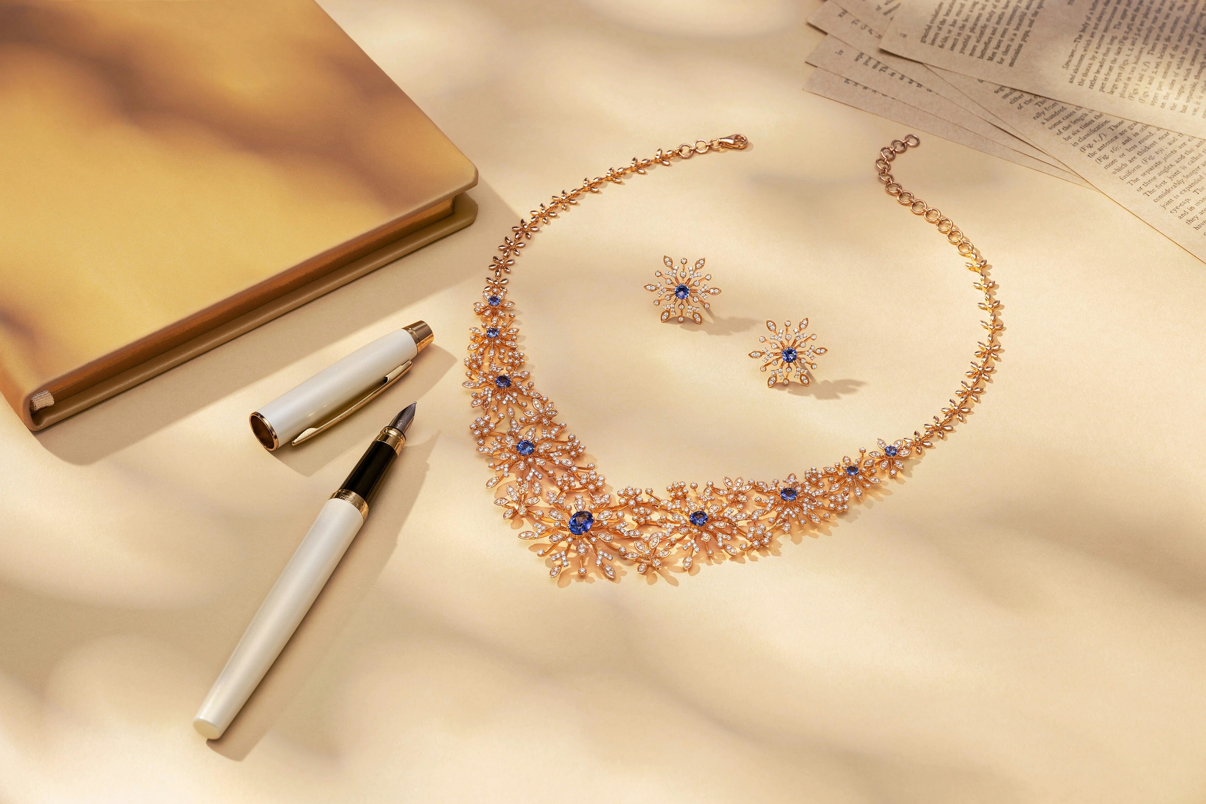 Un collier délicat et des boucles d’oreilles avec un stylo et un carnet.