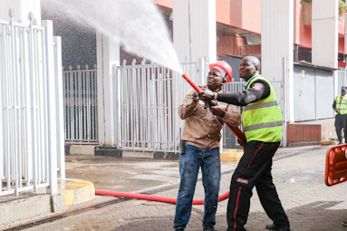 Two men operating a fire hose