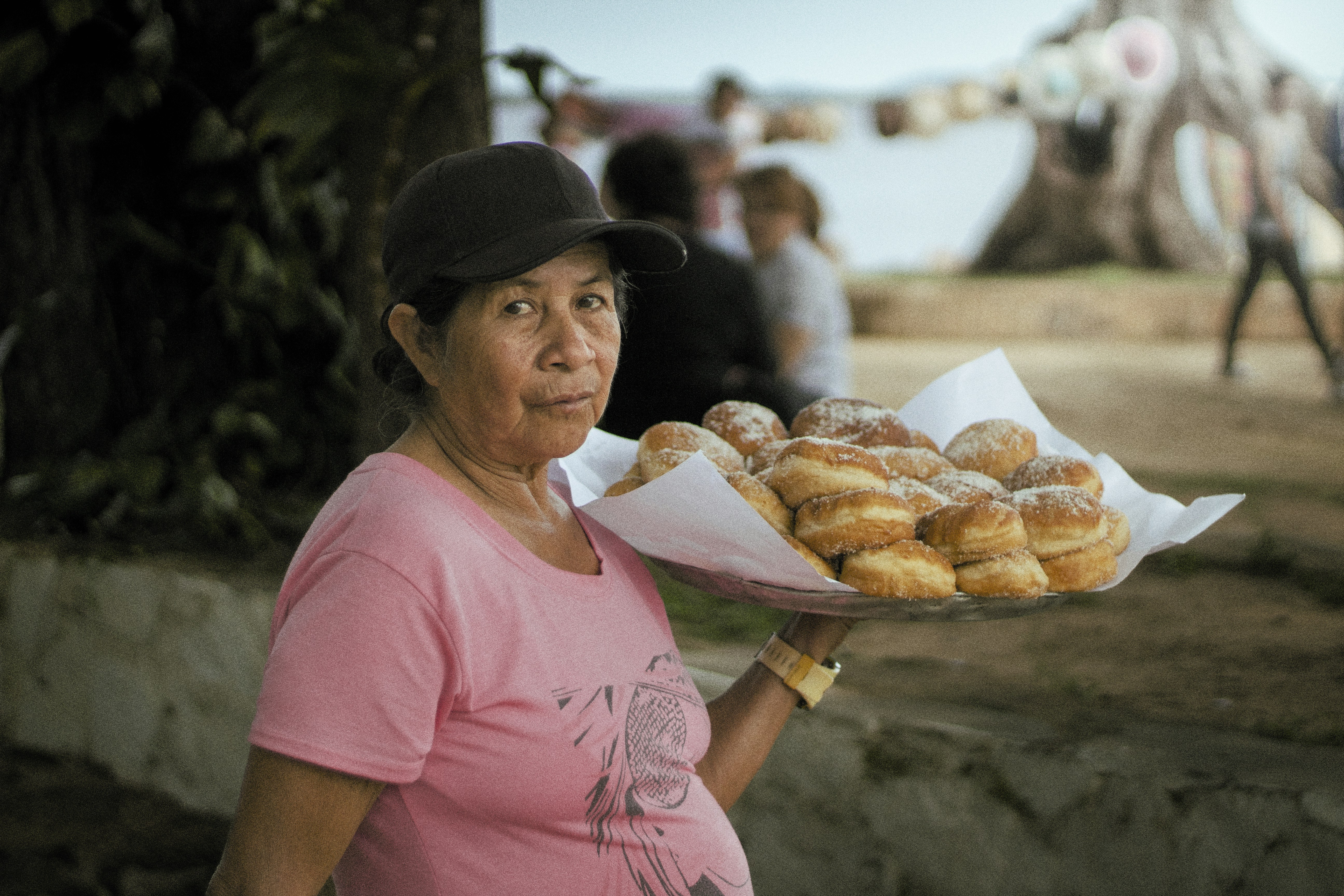 Woman holding a tray of donuts