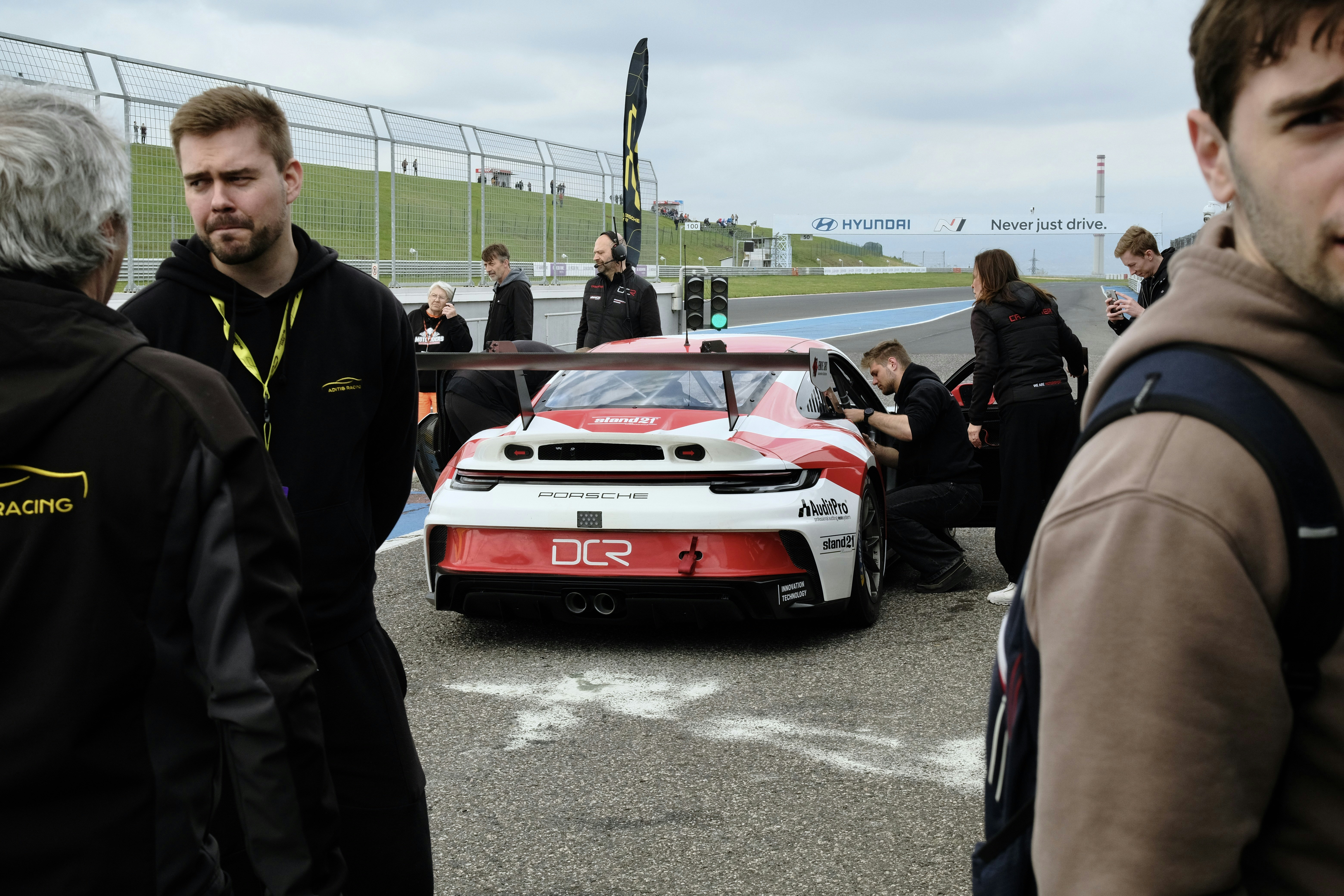 Equipo de coche de carreras trabajando en un coche deportivo en pista