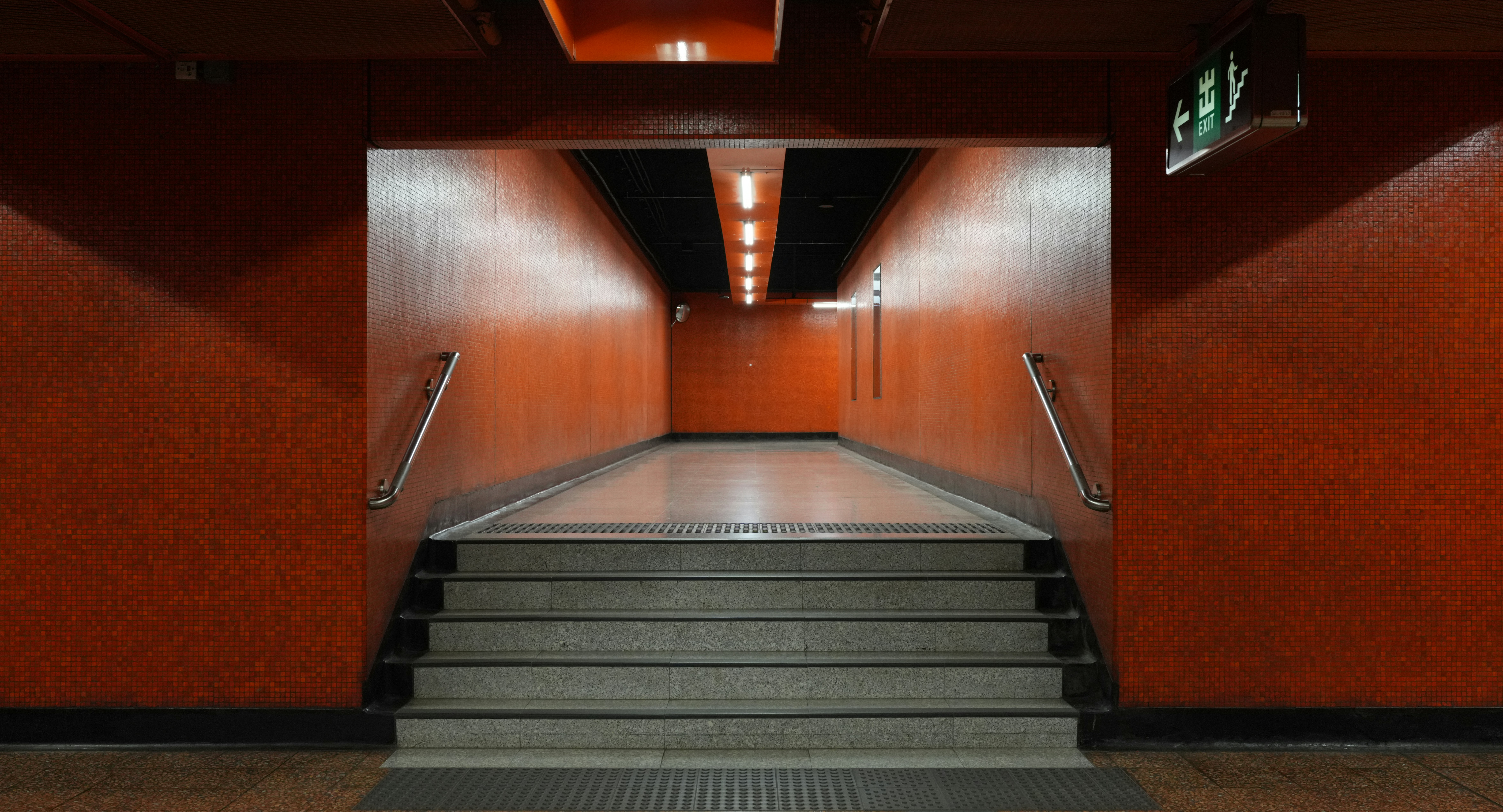 Orange hallway with stairs leading into a tunnel.