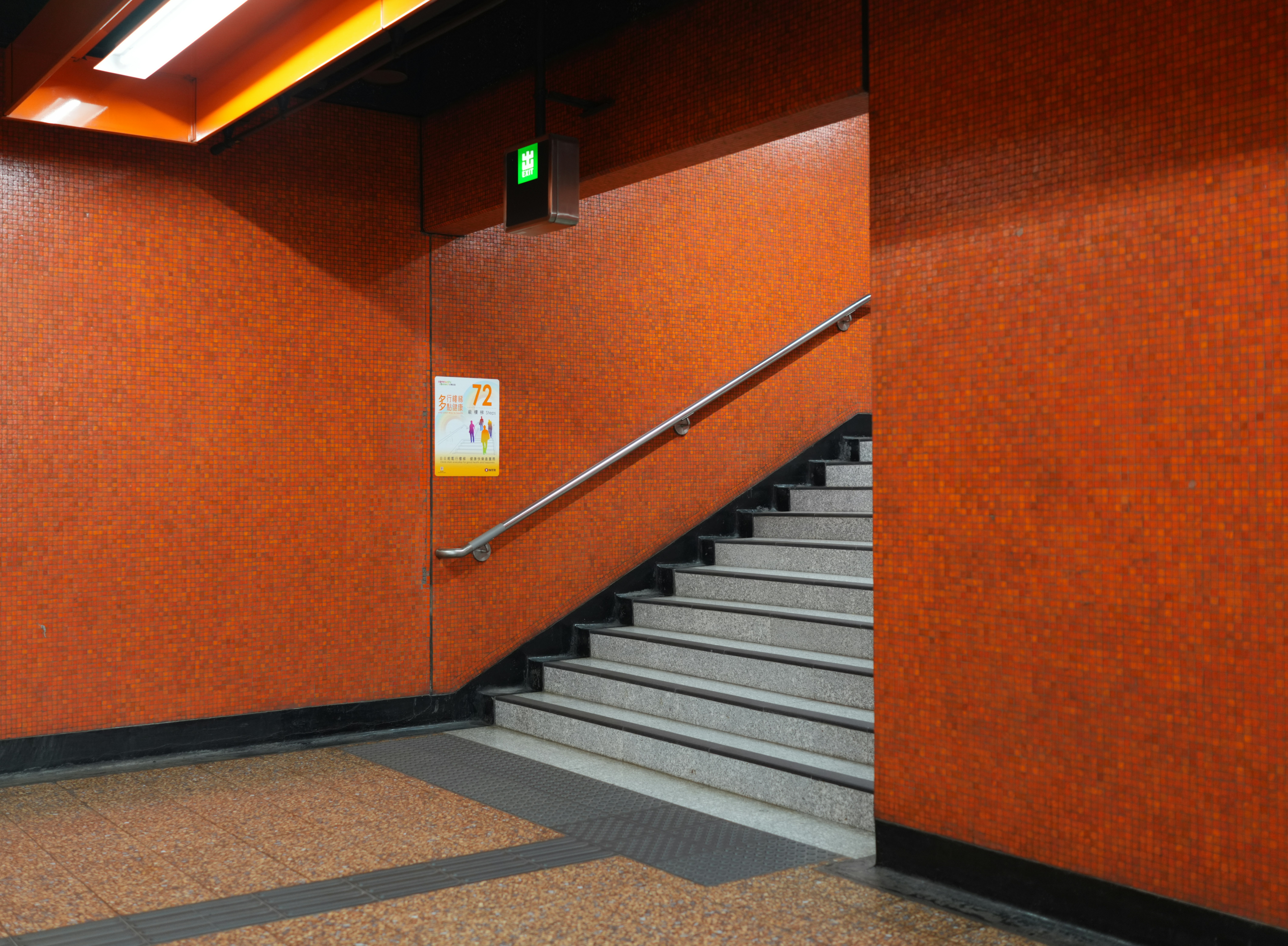 Orange tiled walls lead up a staircase.