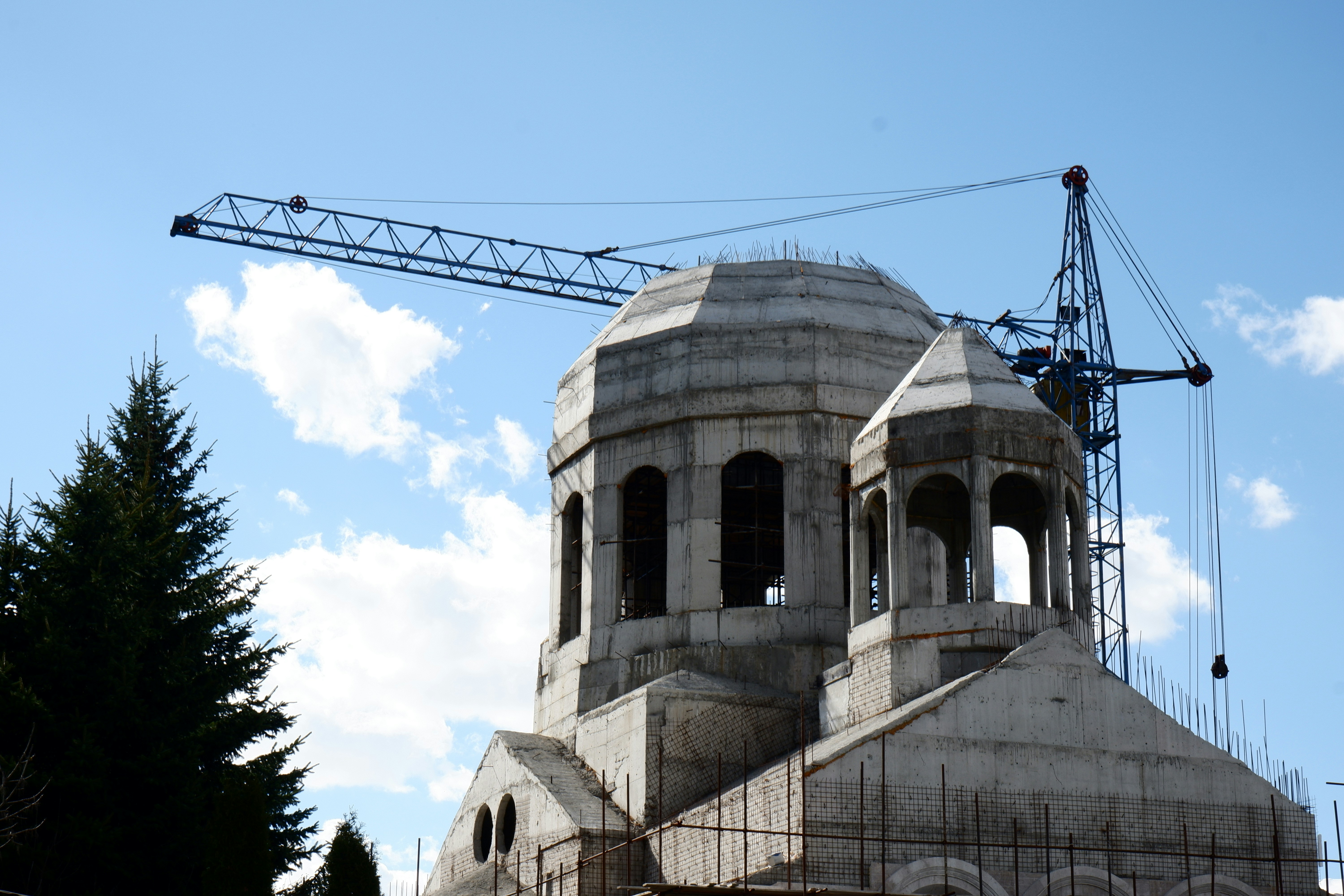 Church construction with crane against blue sky