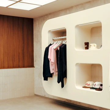 Modern retail display with clothing and hats.