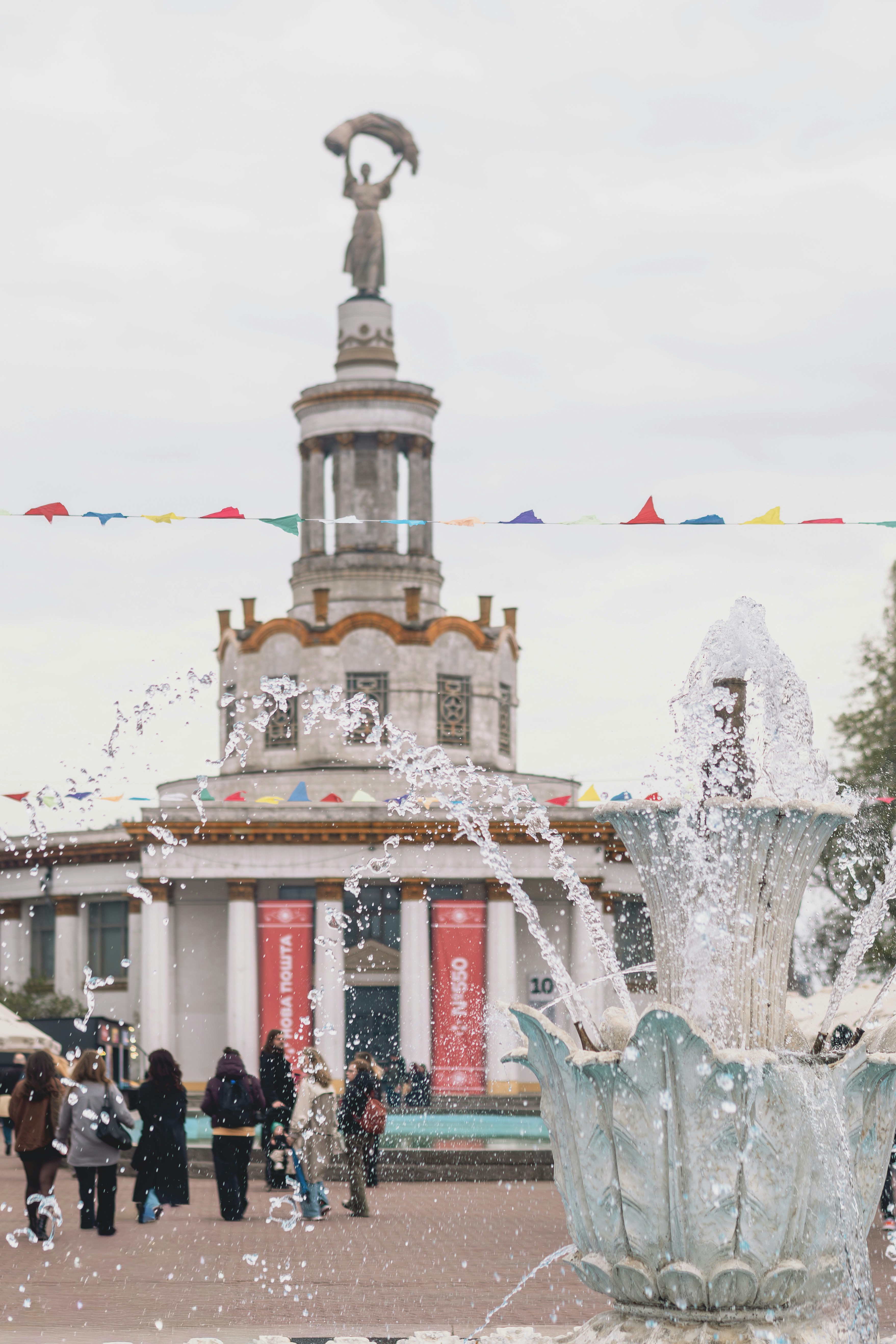 Fountain with people and ornate building in background