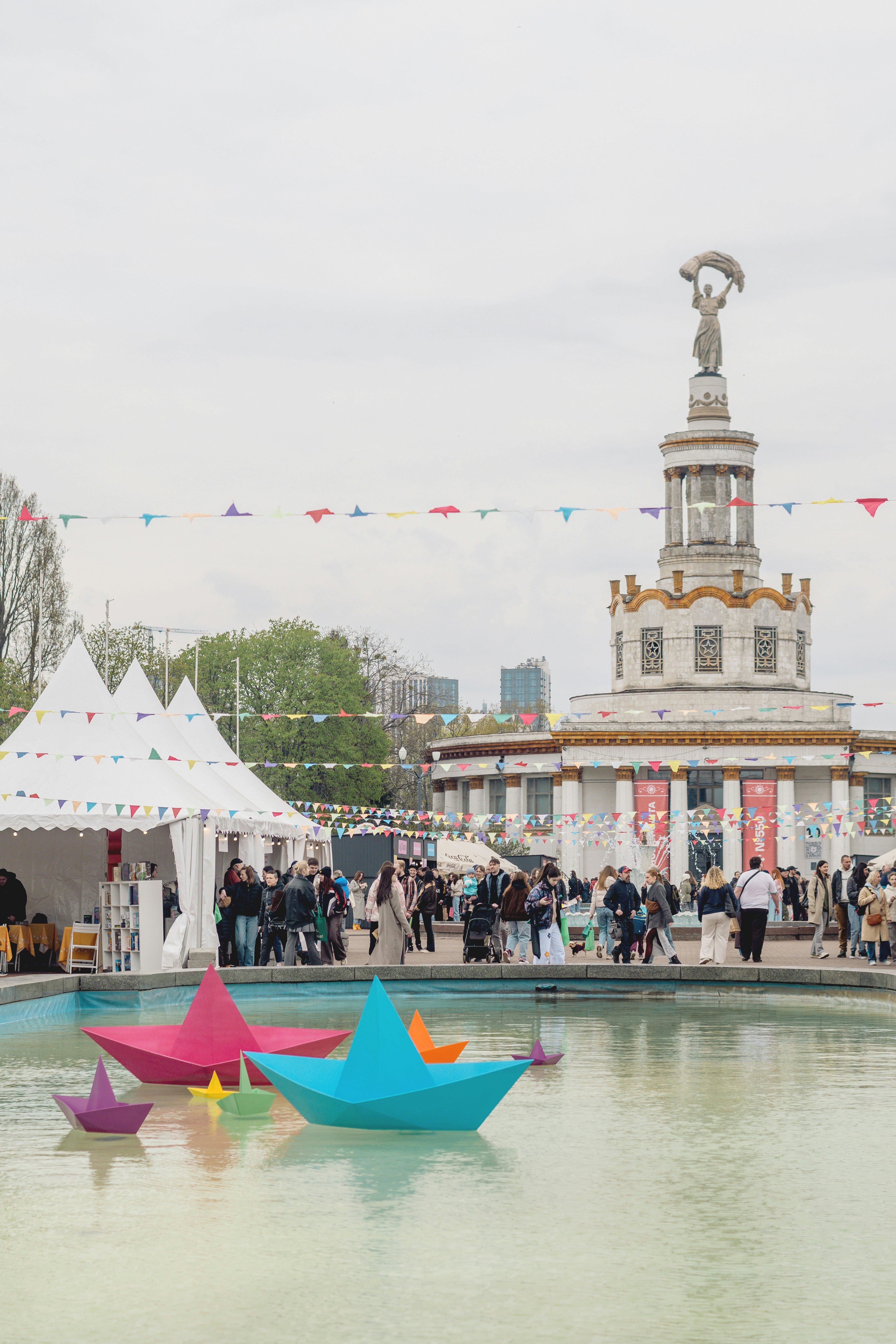 Colorful paper boats float in a fountain near fountain