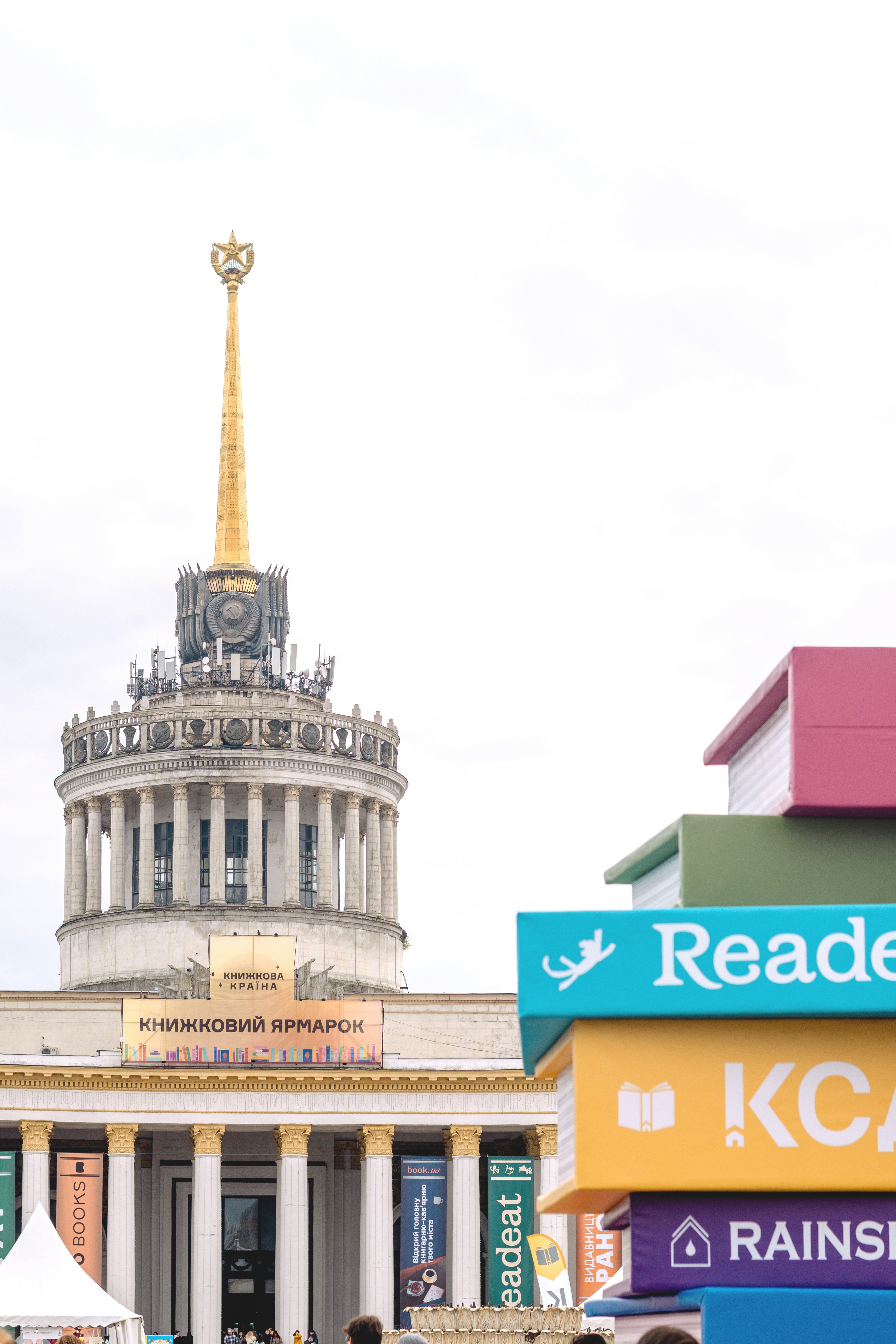 Building with spire and stack of colorful books