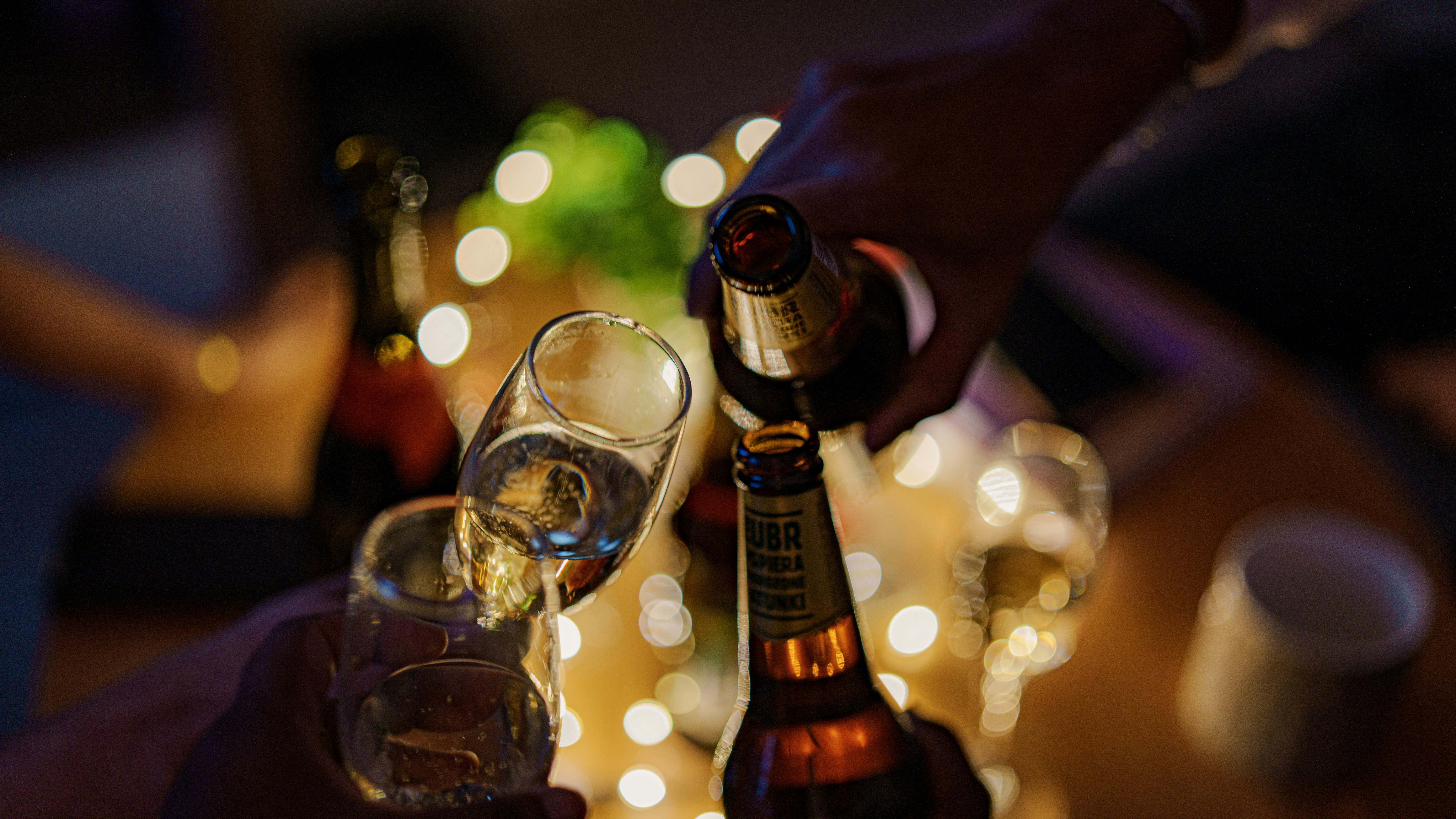 Servindo bebidas com luzes de bokeh ao fundo