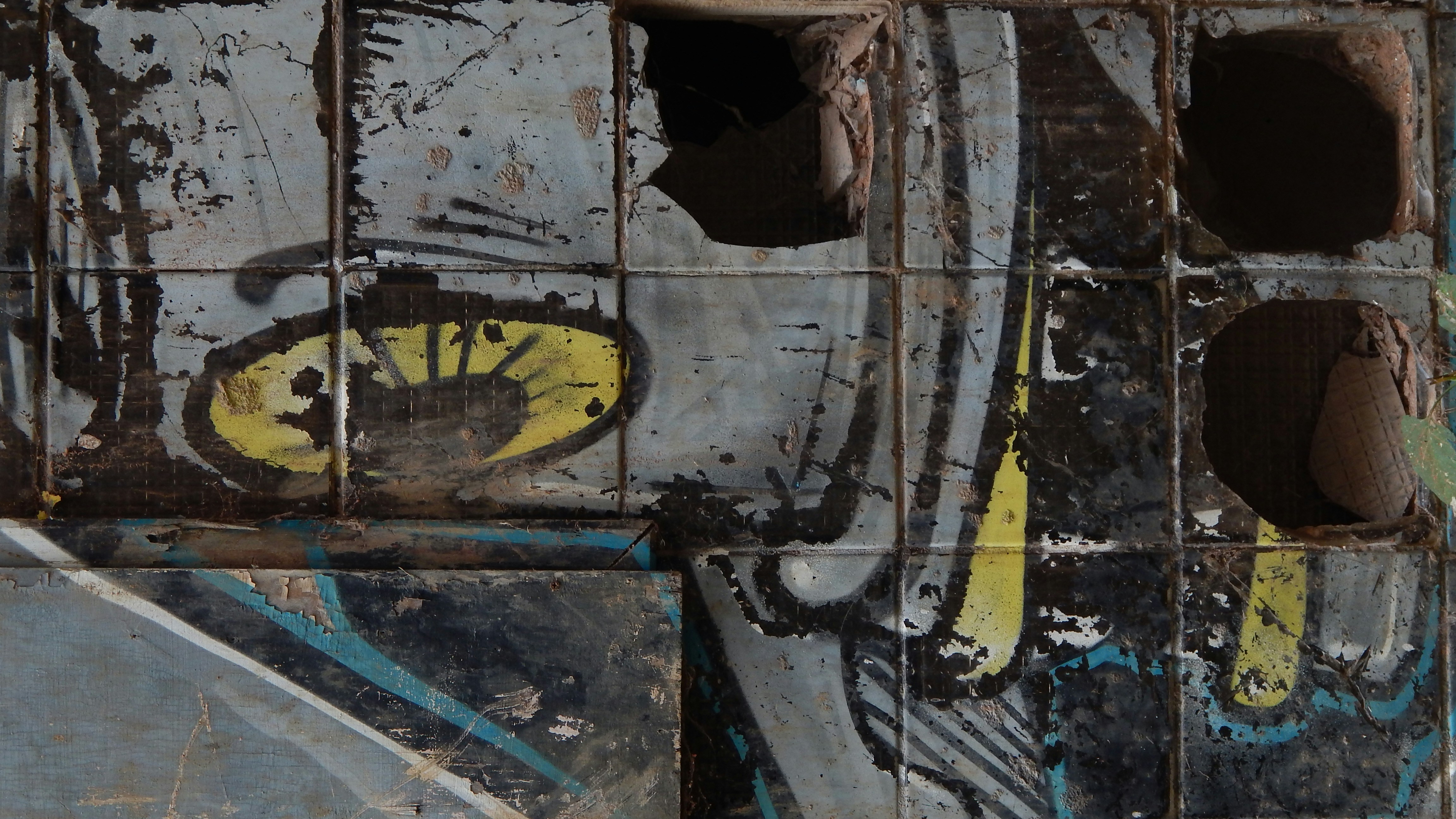 Graffiti art on a tiled, weathered wall