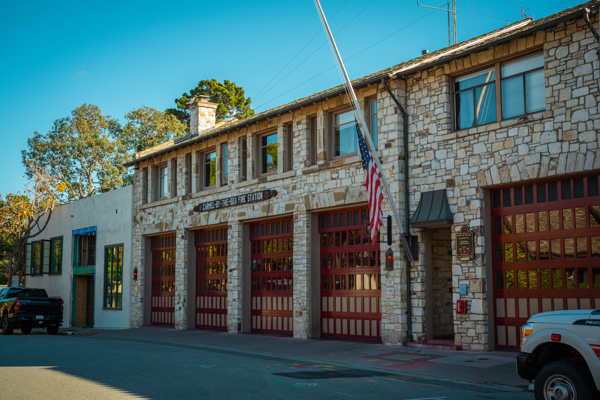 Stone building with multiple garage doors and american flag.