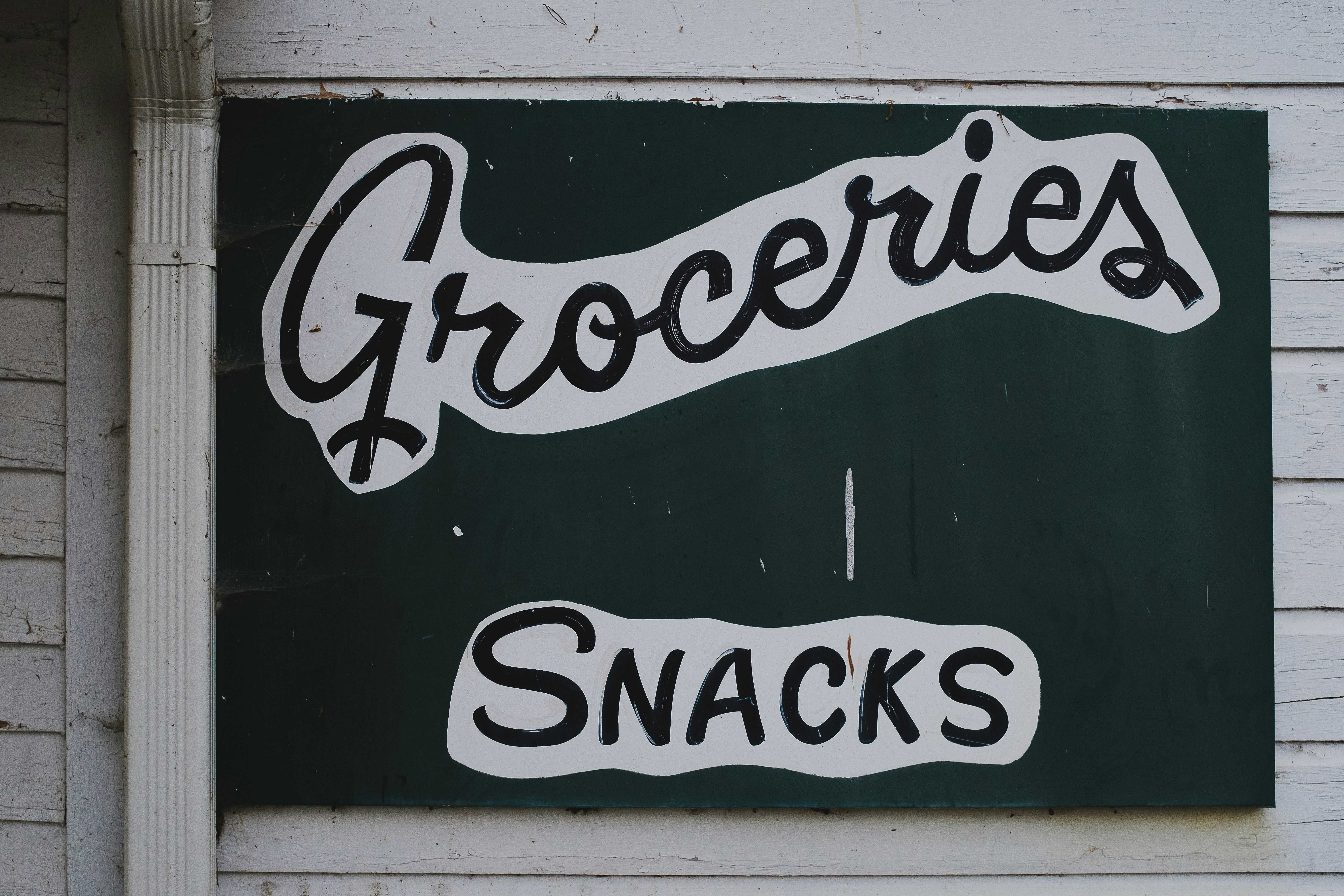 Groceries and snacks sign on wooden wall