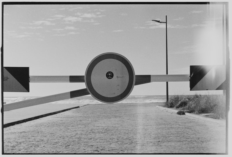 A closed road barrier with a circular sign.