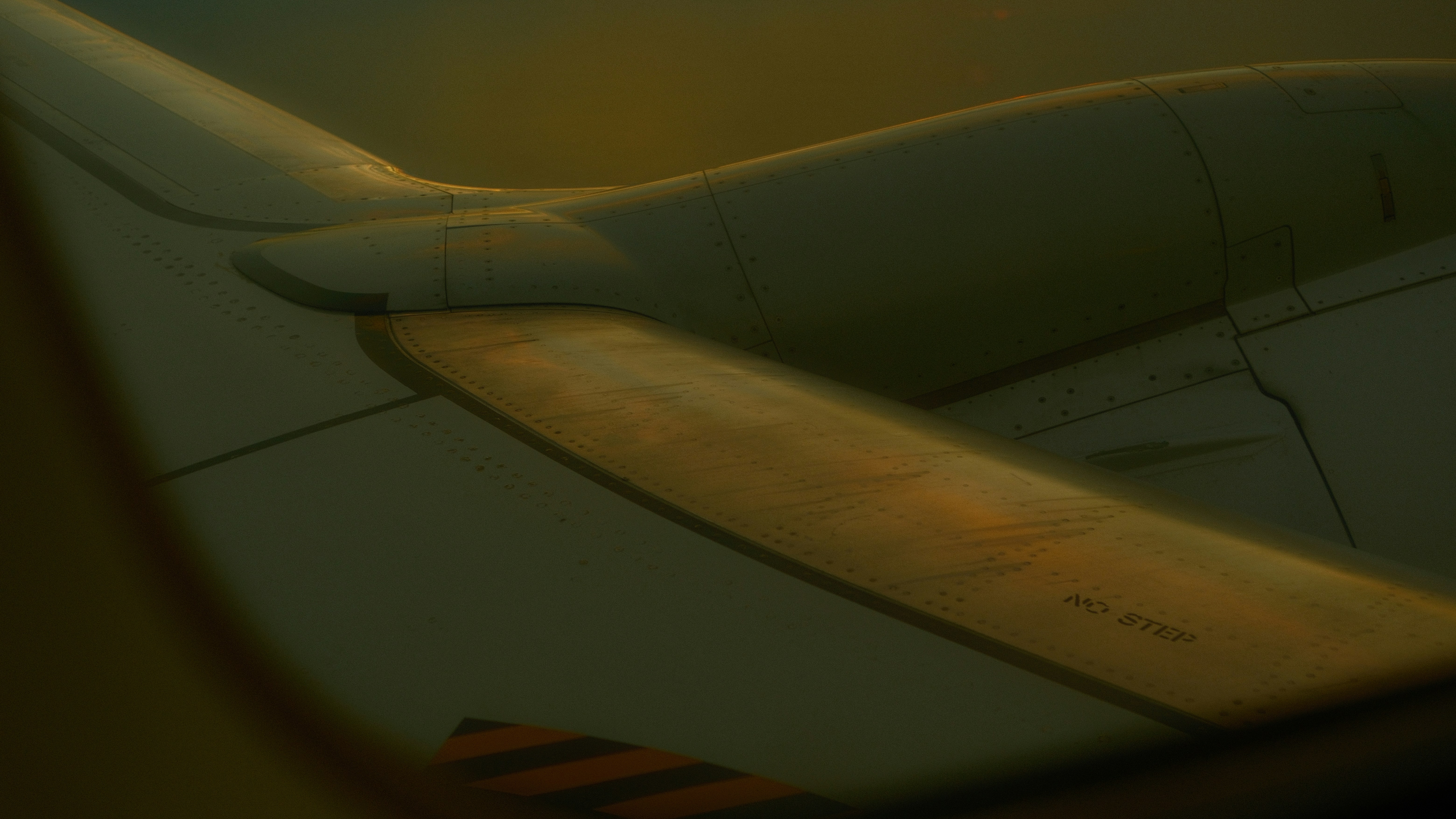 Close-up of an airplane wing at sunset.
