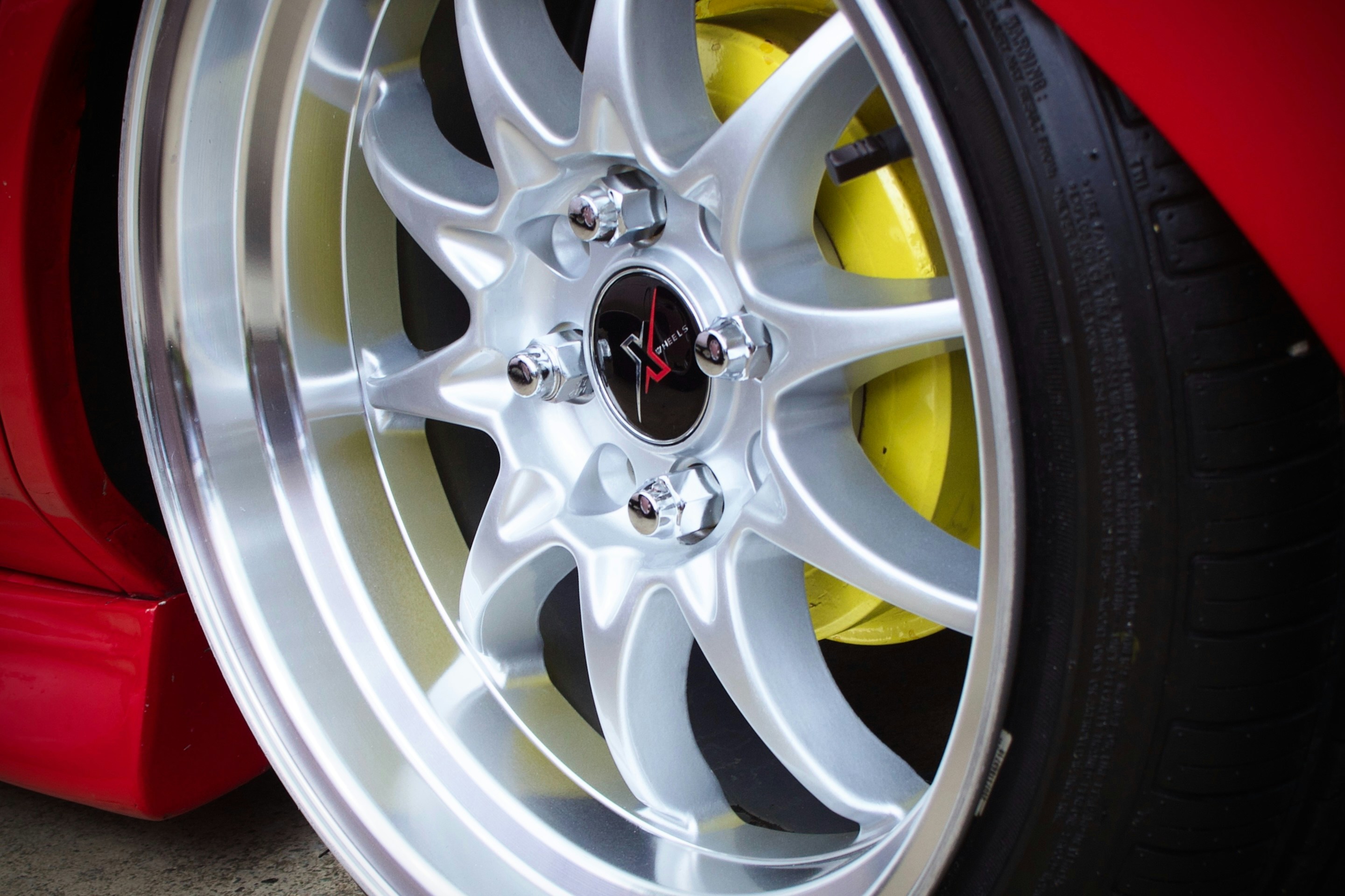 Close-up of a silver alloy wheel with yellow brake caliper.