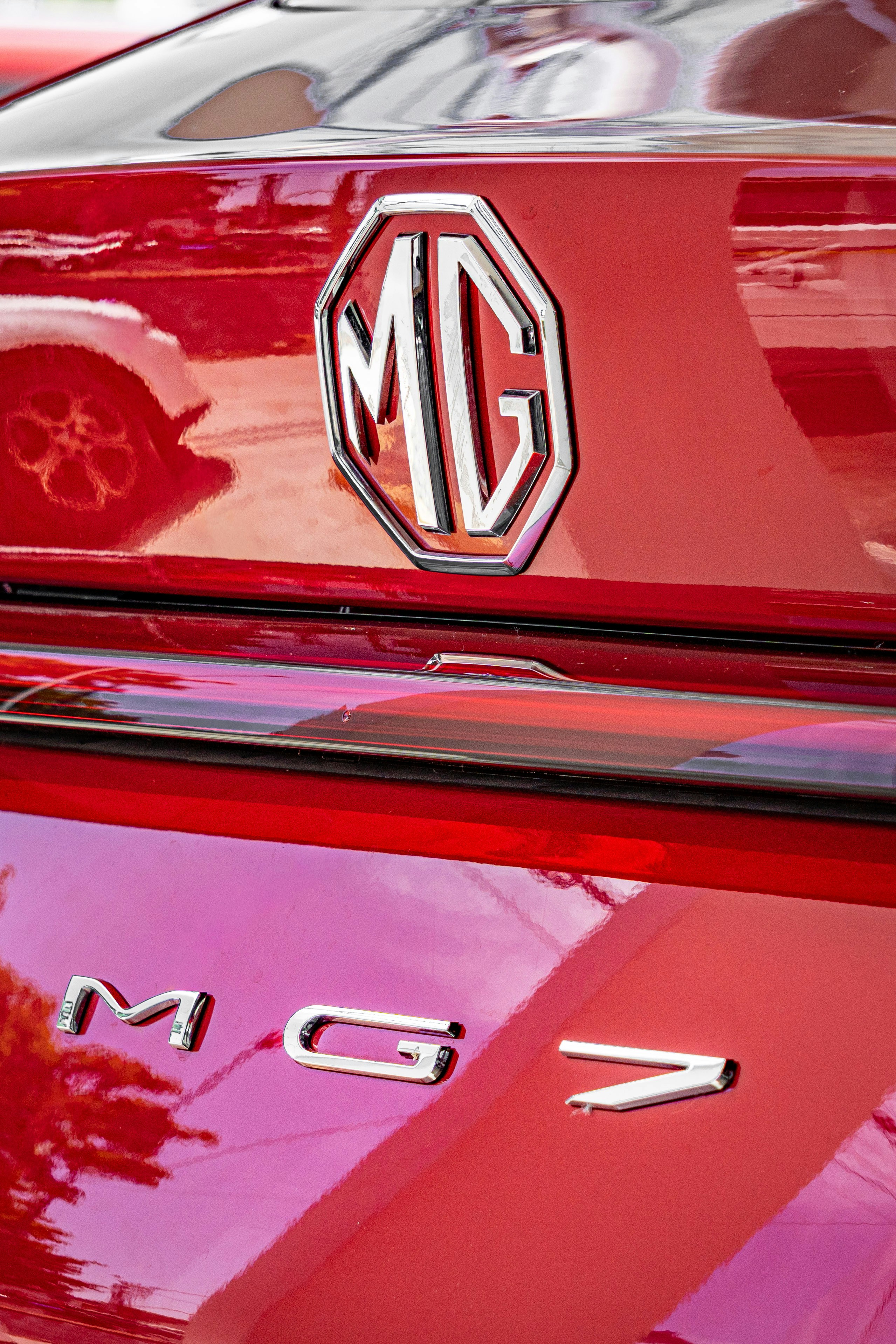 Close-up of a red mg car emblem and its emblem