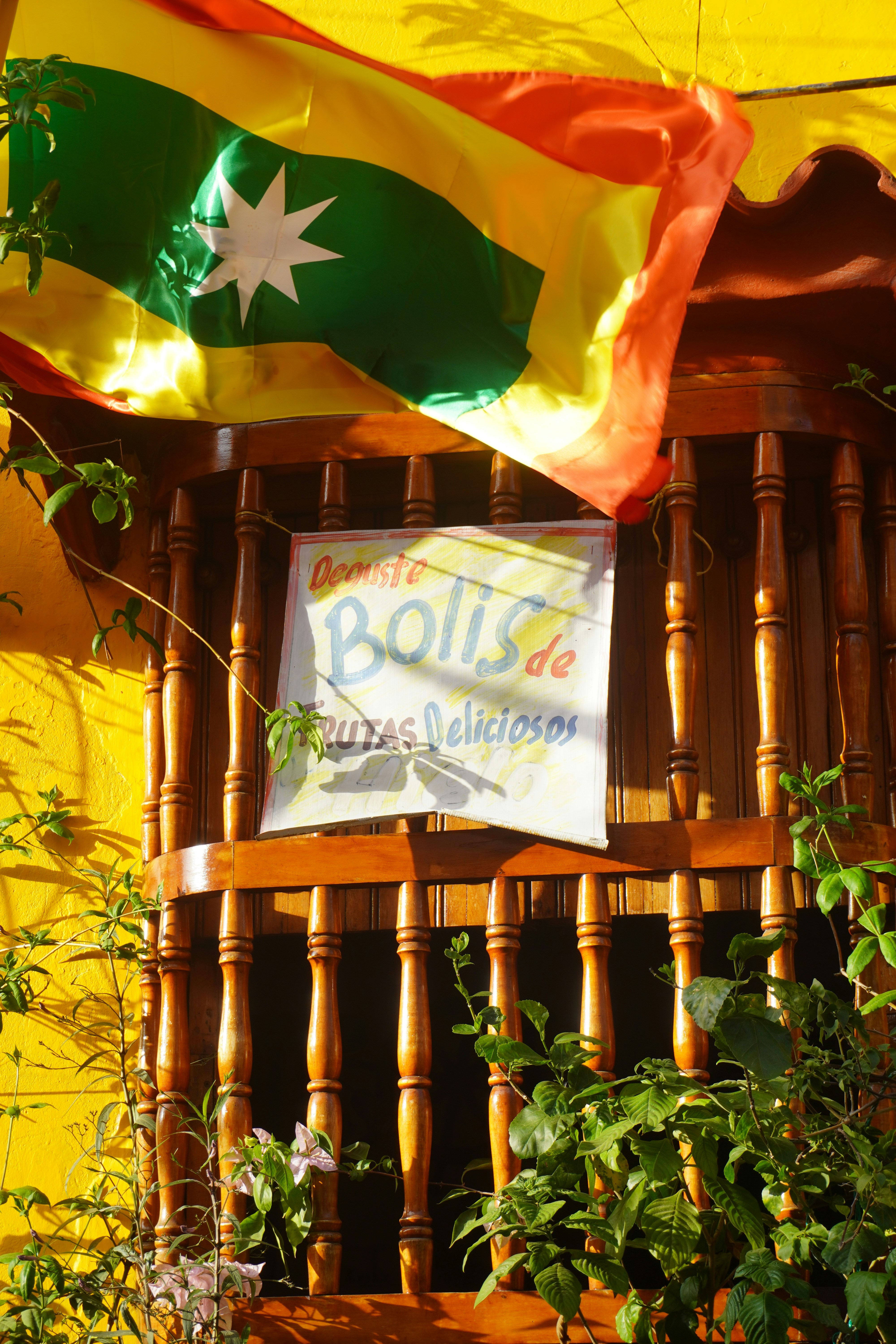 Bendera Kolombia berkibar di atas balkon kayu dengan tanda.