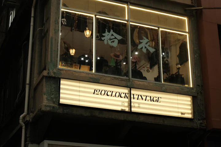 A vintage clothing store with a lit sign