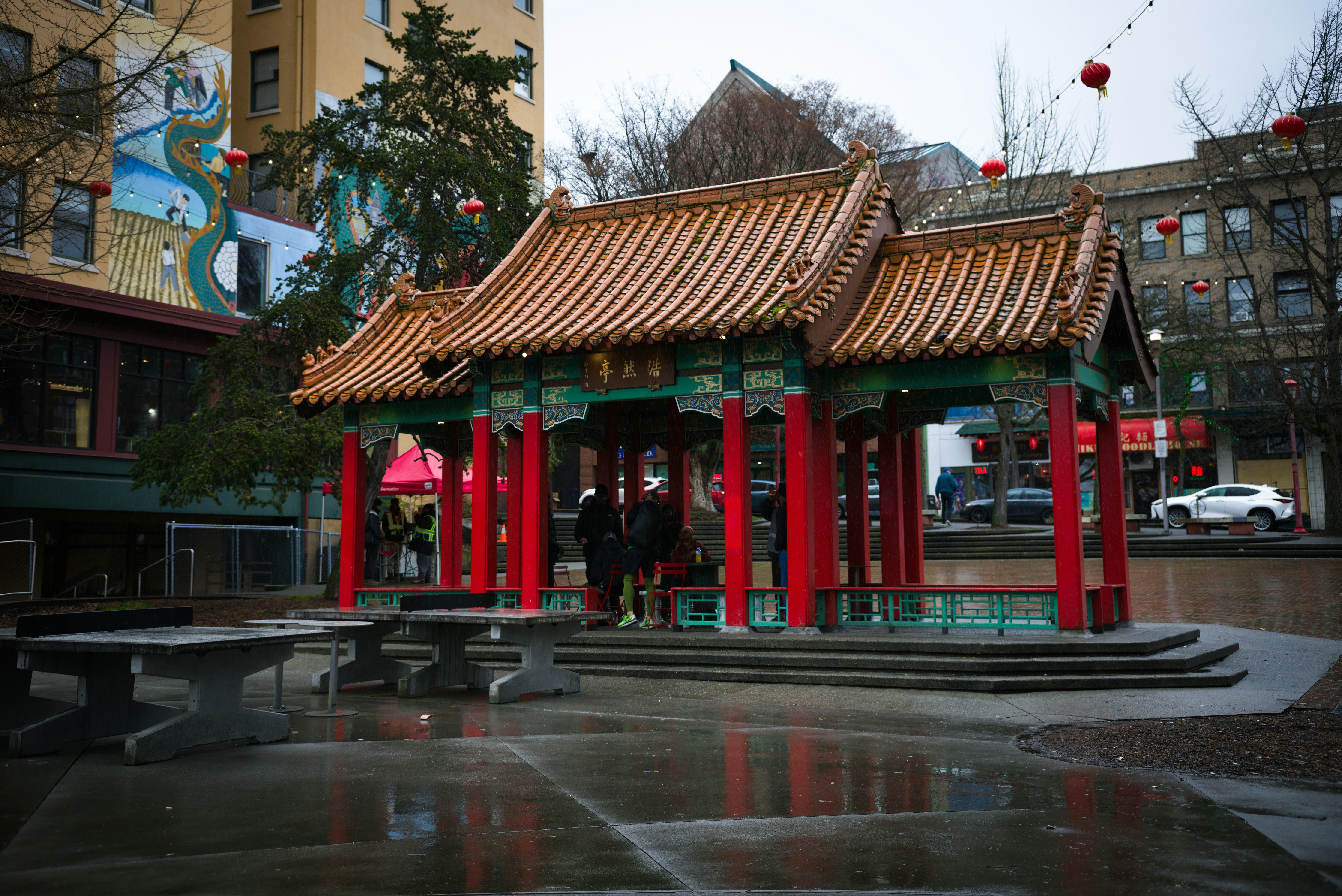 Traditional chinese pavilion with red columns in a city square.